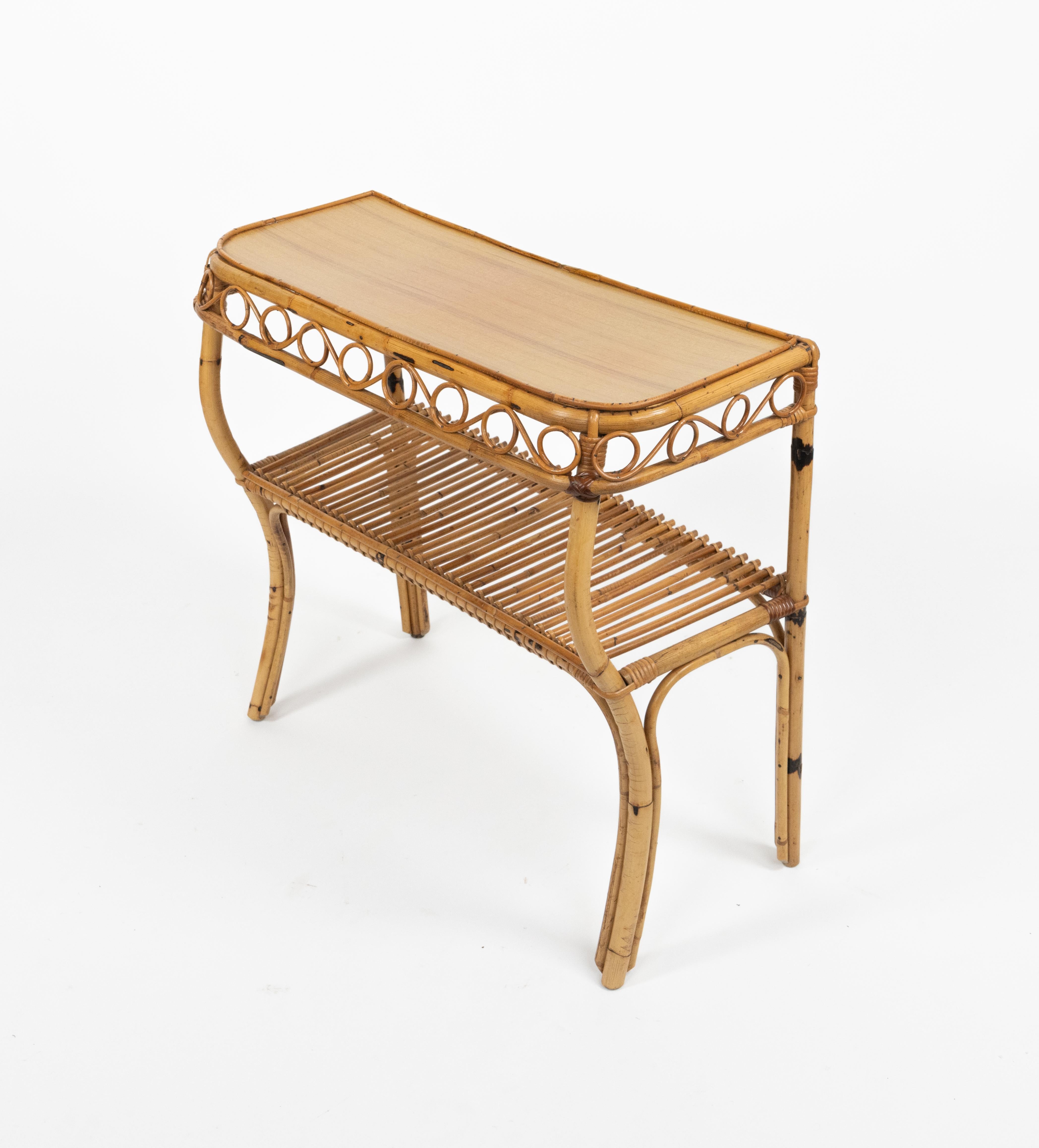 Midcentury beautiful console table in rattan and bamboo featuring a lower shelf in the style of the Italian designer Franco Albini. 

Made in Italy in the 1960s.22