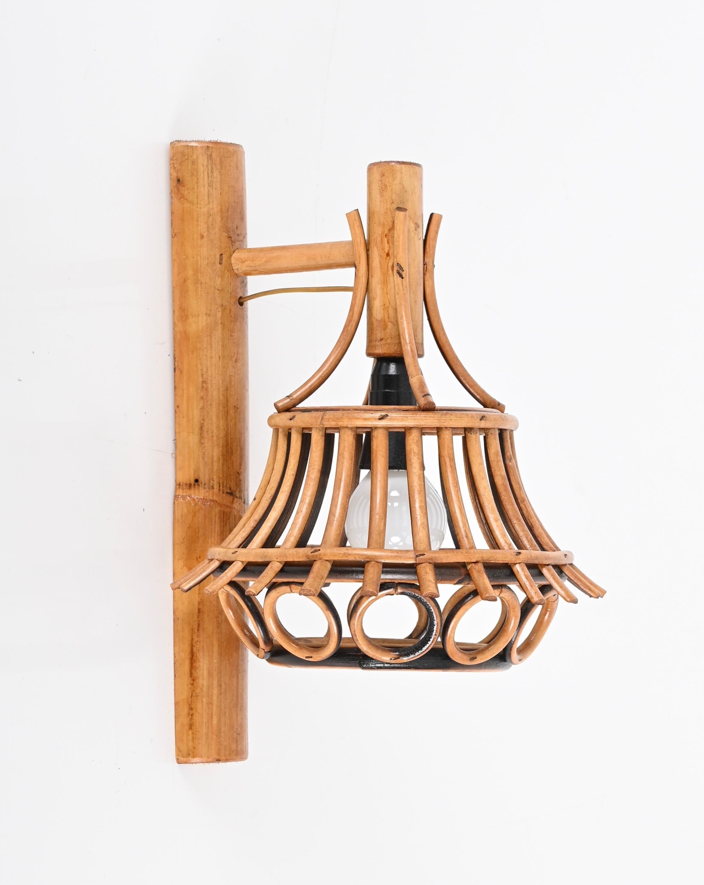 Stunning wall lamp in rattan and bamboo produced in the 1960s in France and attributed to Louis Sognot. 

This rare and charming sconce feature a round shade with perfect geometric decorations in curved rattan. A great example of French organic