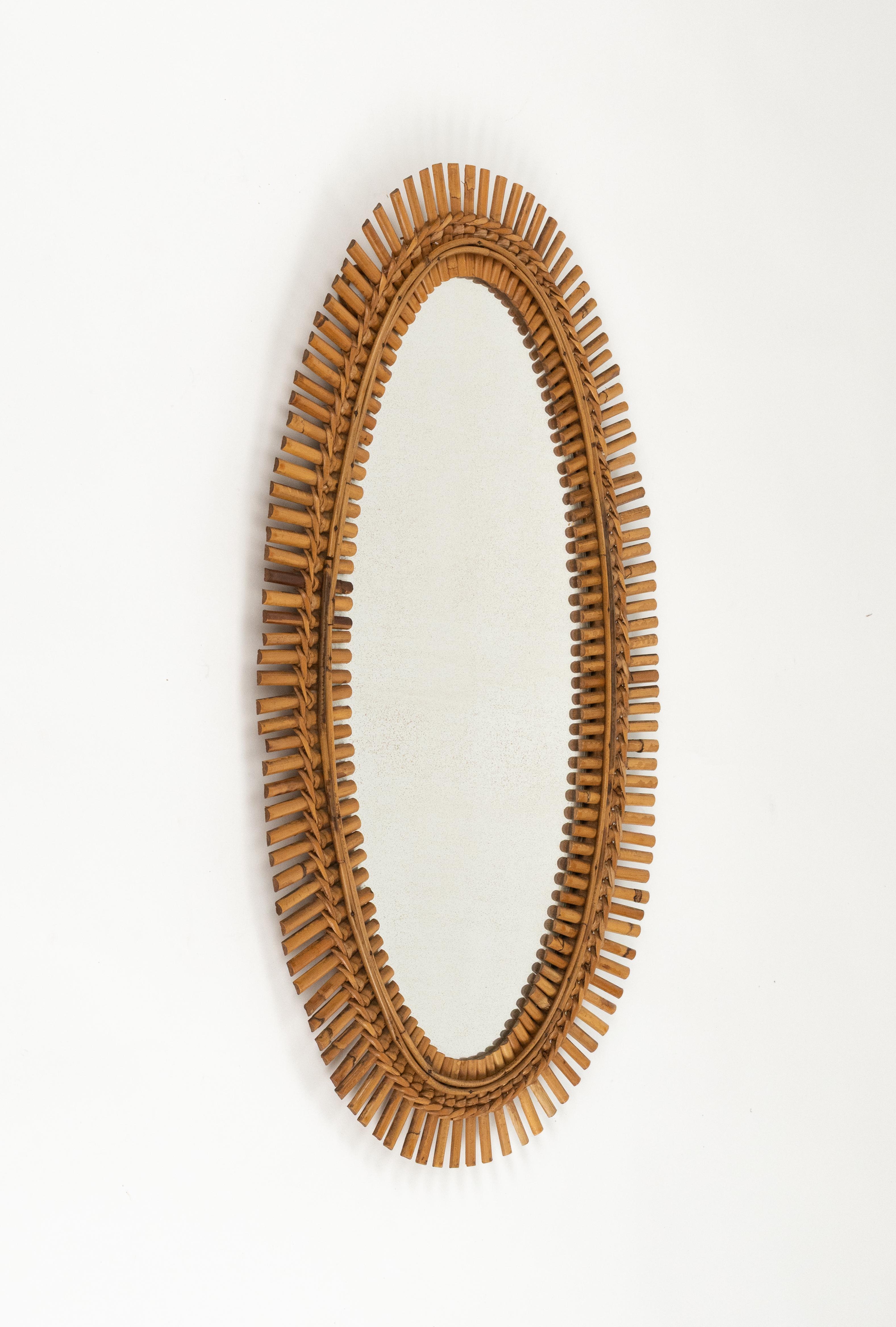 Miroir mural ovale en bambou et rotin dans le style de Franco Albini.  

Fabriqué en Italie dans les années 1960.   

Un miroir en bambou et rotin très décoratif au goût de la côte méditerranéenne.

Le miroir, original de l'époque.
