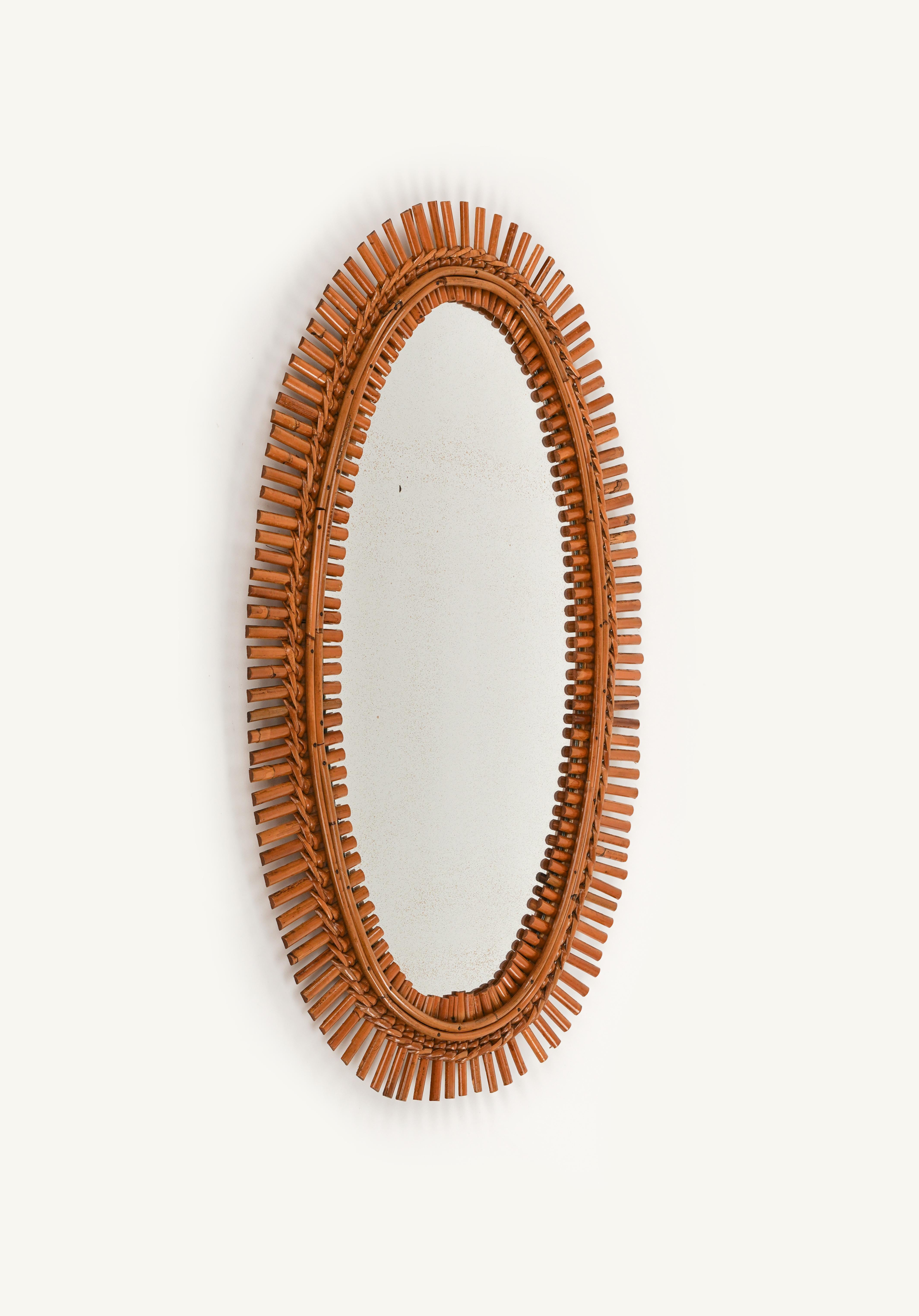 Schöner ovaler Wandspiegel aus Rattan und Bambus im Stil von Franco Albini aus der Mitte des Jahrhunderts.

Hergestellt in Italien in den 1960er Jahren.

Der Spiegel ist original aus der Zeit ist charmant Patina.