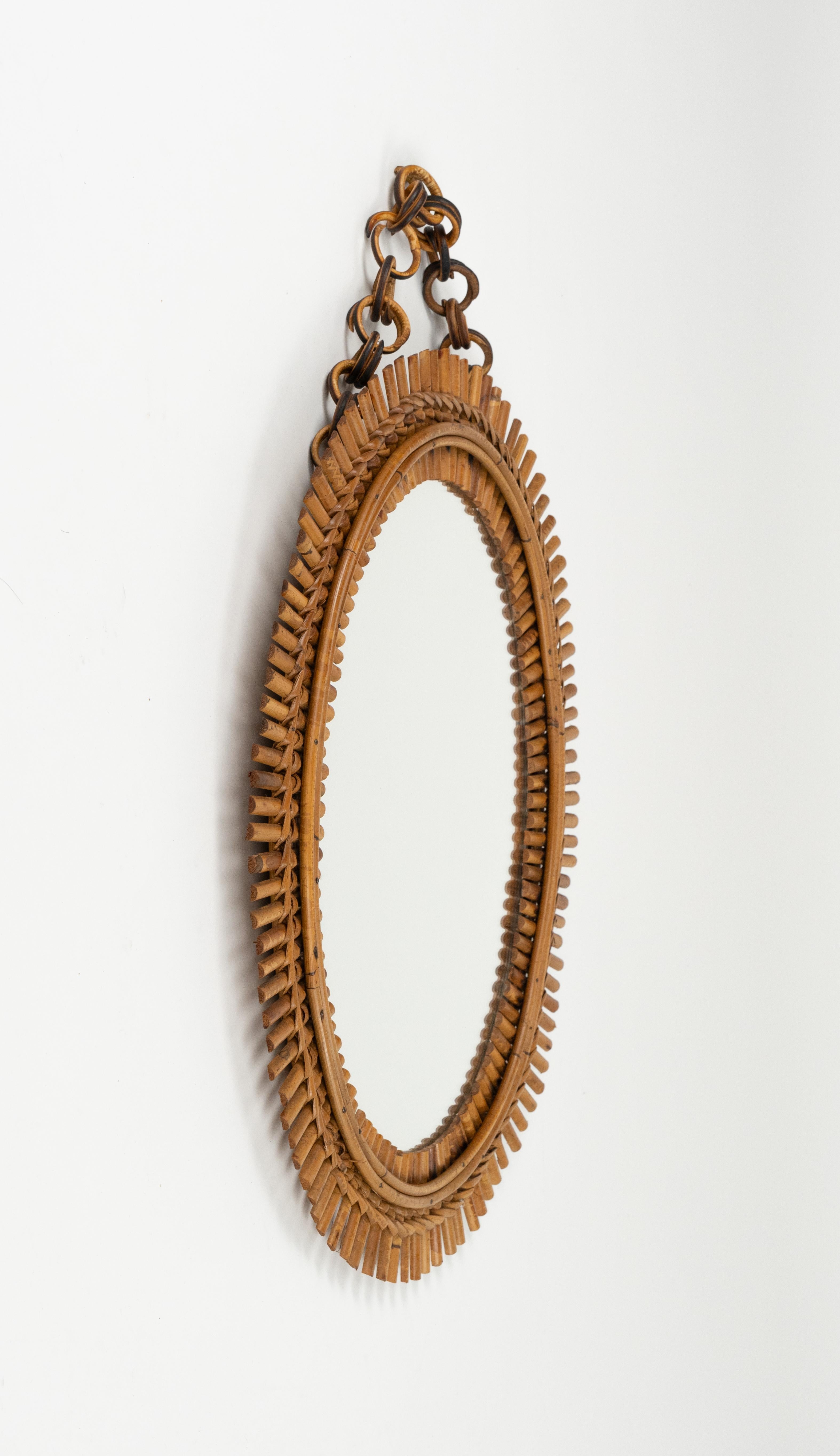 Midcentury beautiful oval wall mirror with chain in bamboo and rattan in the style of Franco Albini.   

Made in Italy in the 1960s.   

A highly decorative mirror. 

Dimensions without chain: 
Height 58 cm. 
Width 47 cm. 
Depth 4 cm.