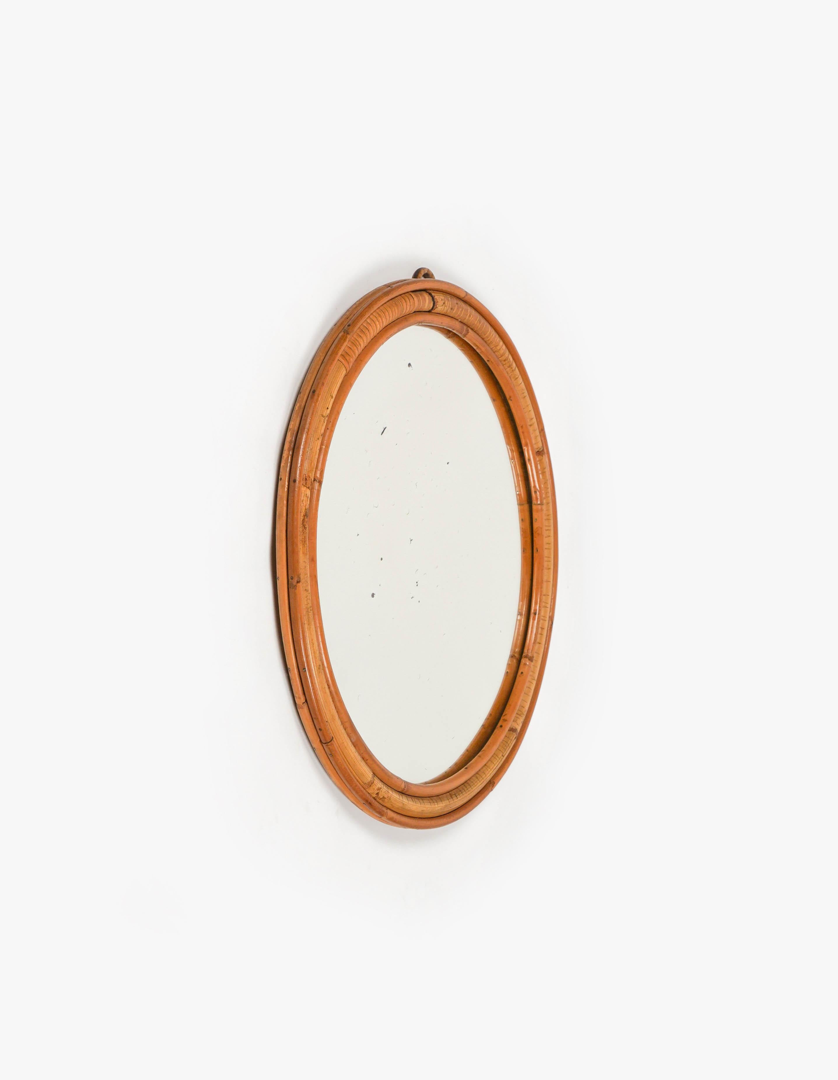 Midcentury Beautiful round wall mirror in bamboo and rattan.  

Made in Italy in the 1960s.  

The mirror, original of the period, shows signs of discolouration.