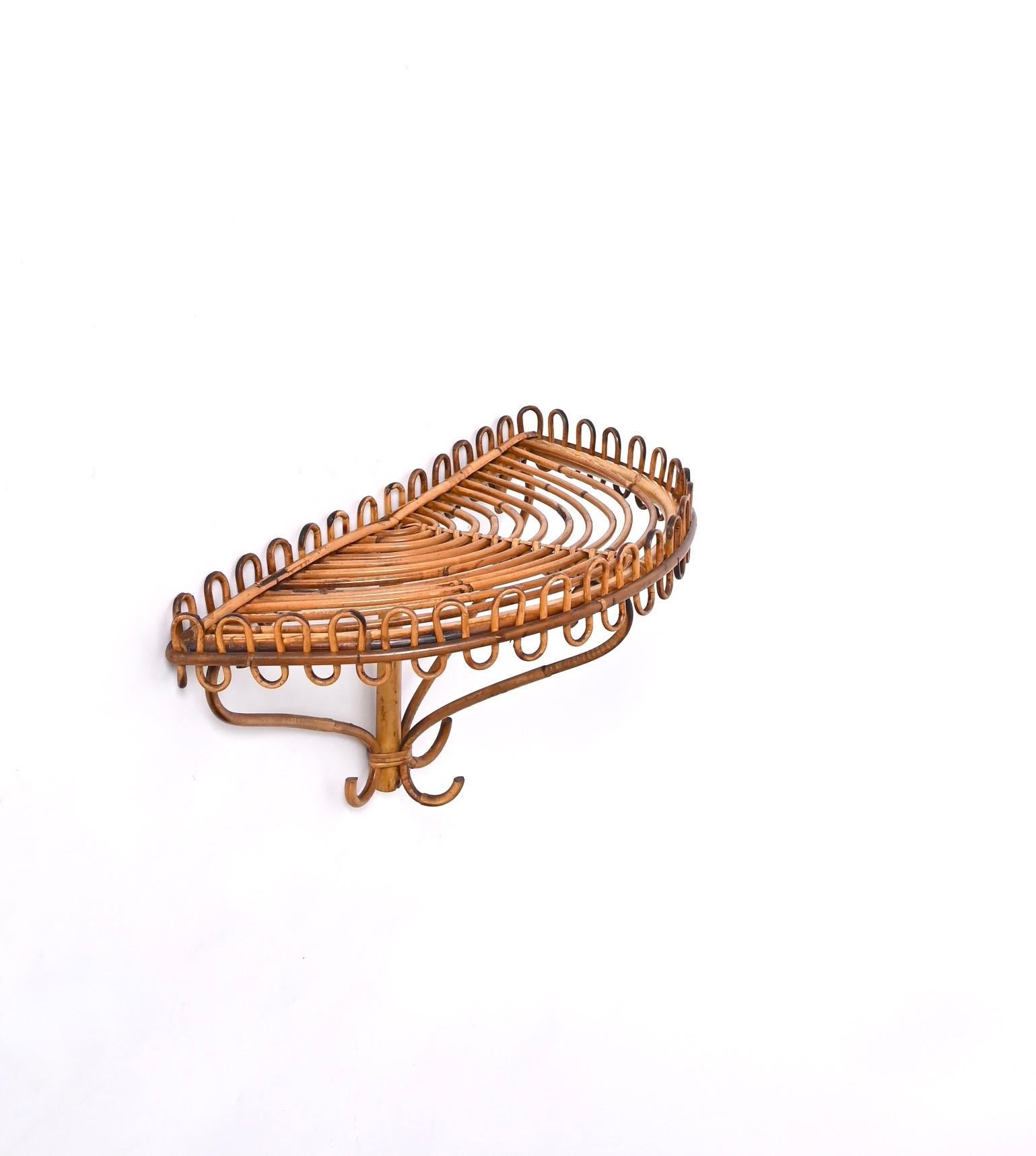 Extraordinary midcentury Bamboo and Rattan Wall Shelf. This marvellous object was made in Italy in the 1960s and is attributed to the mastery of Franco Albini.

This fantastic shelf consist of a curved structure and base in bamboo and rattan, the