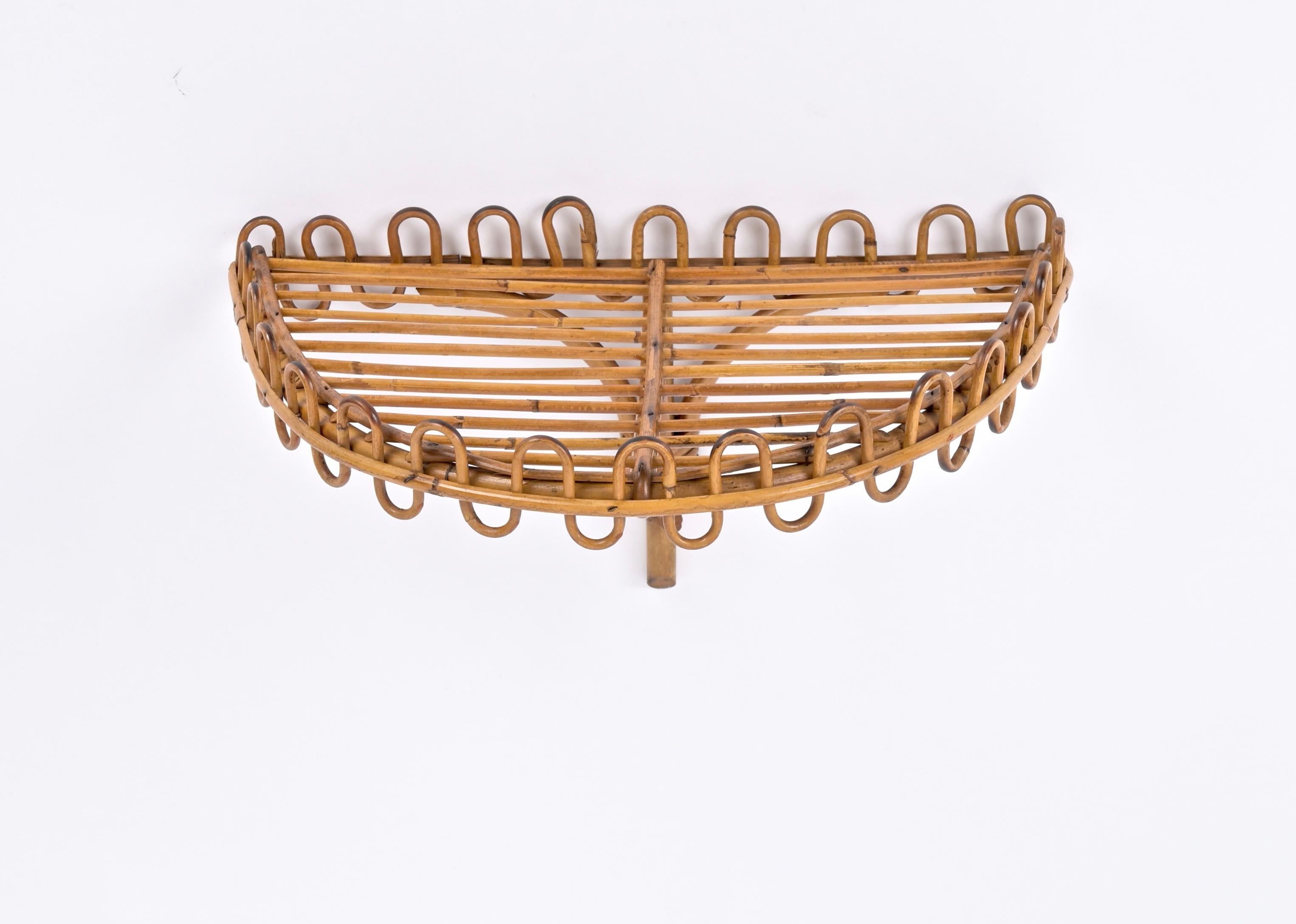 Extraordinary Mid-Century wall shelf in curved rattan, bamboo and wicker. This marvellous object was made in Italy in the 1960s and is attributed to the mastery of Franco Albini.

This fantastic shelf consist of an half-moon shaped shelf mounted