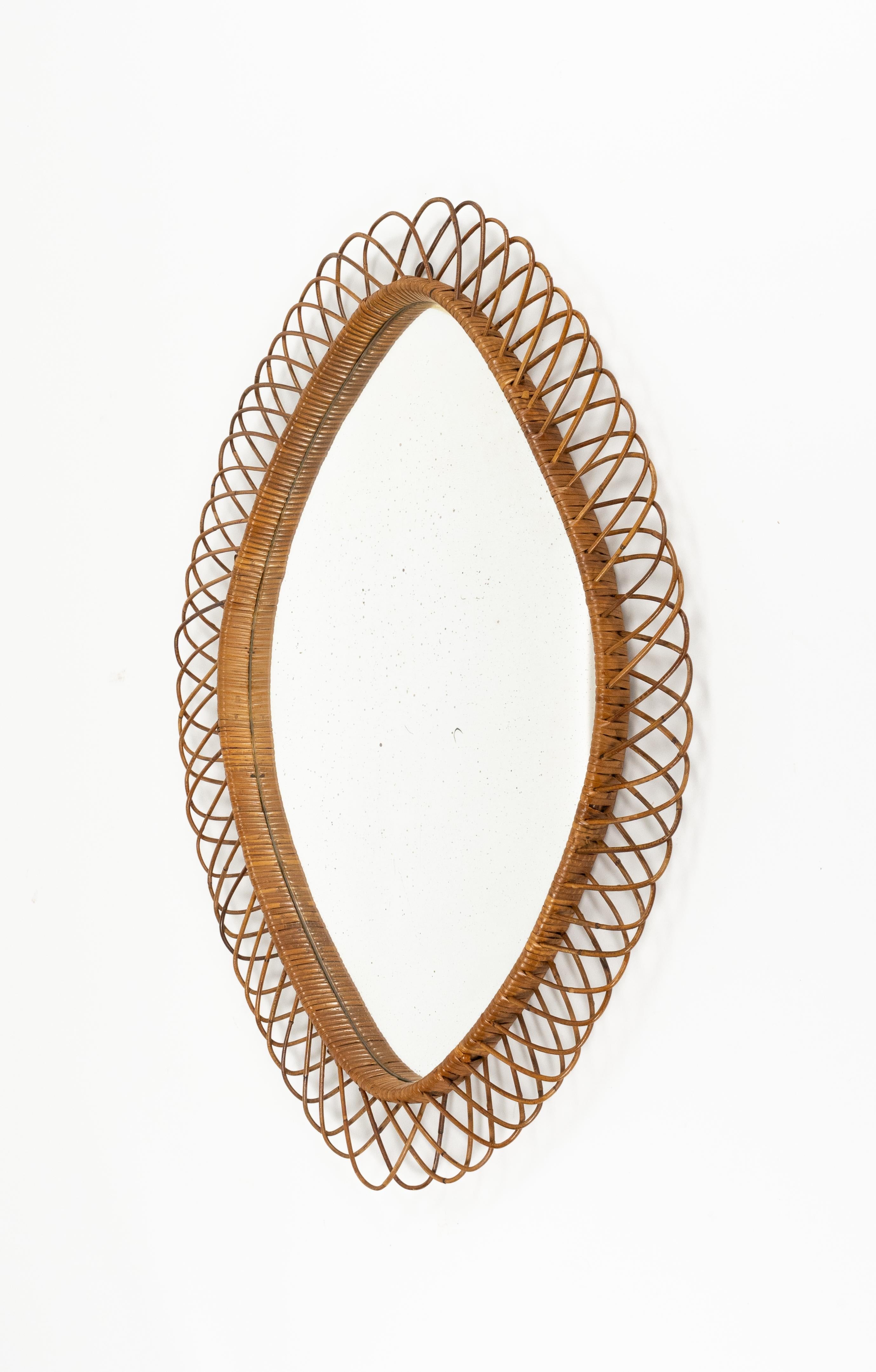 Specchio da parete ovale e a rombi in rattan e vimini.

Prodotto in Italia negli anni '1960.

Lo specchio, originale dell'epoca, presenta segni di scolorimento.