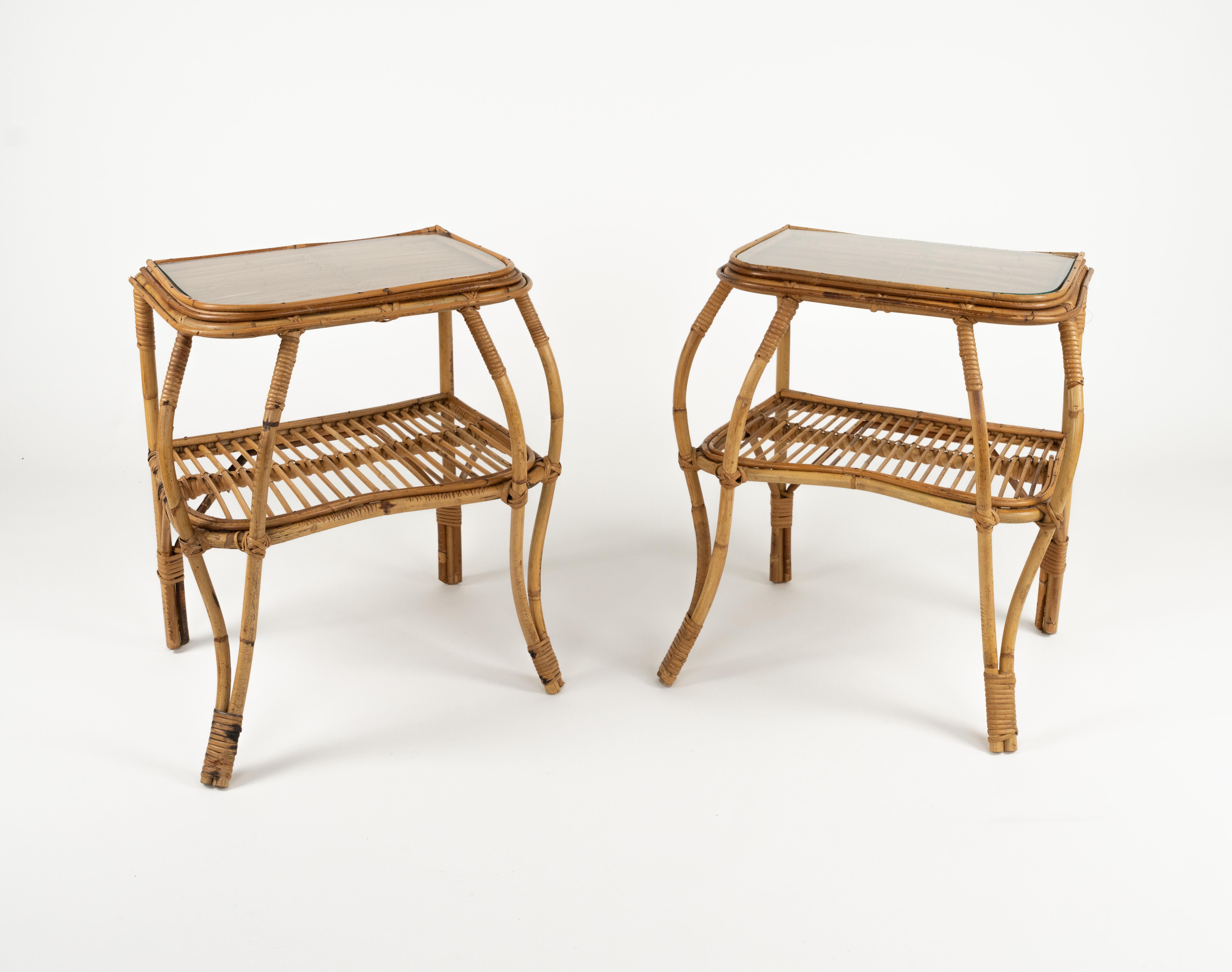 Midcentury amazing pair of bedside tables in bamboo, rattan and glass top.

Made in Italy in the 1960s.

Sinuous shapes of legs adds fullness whilst keeping its lightness .