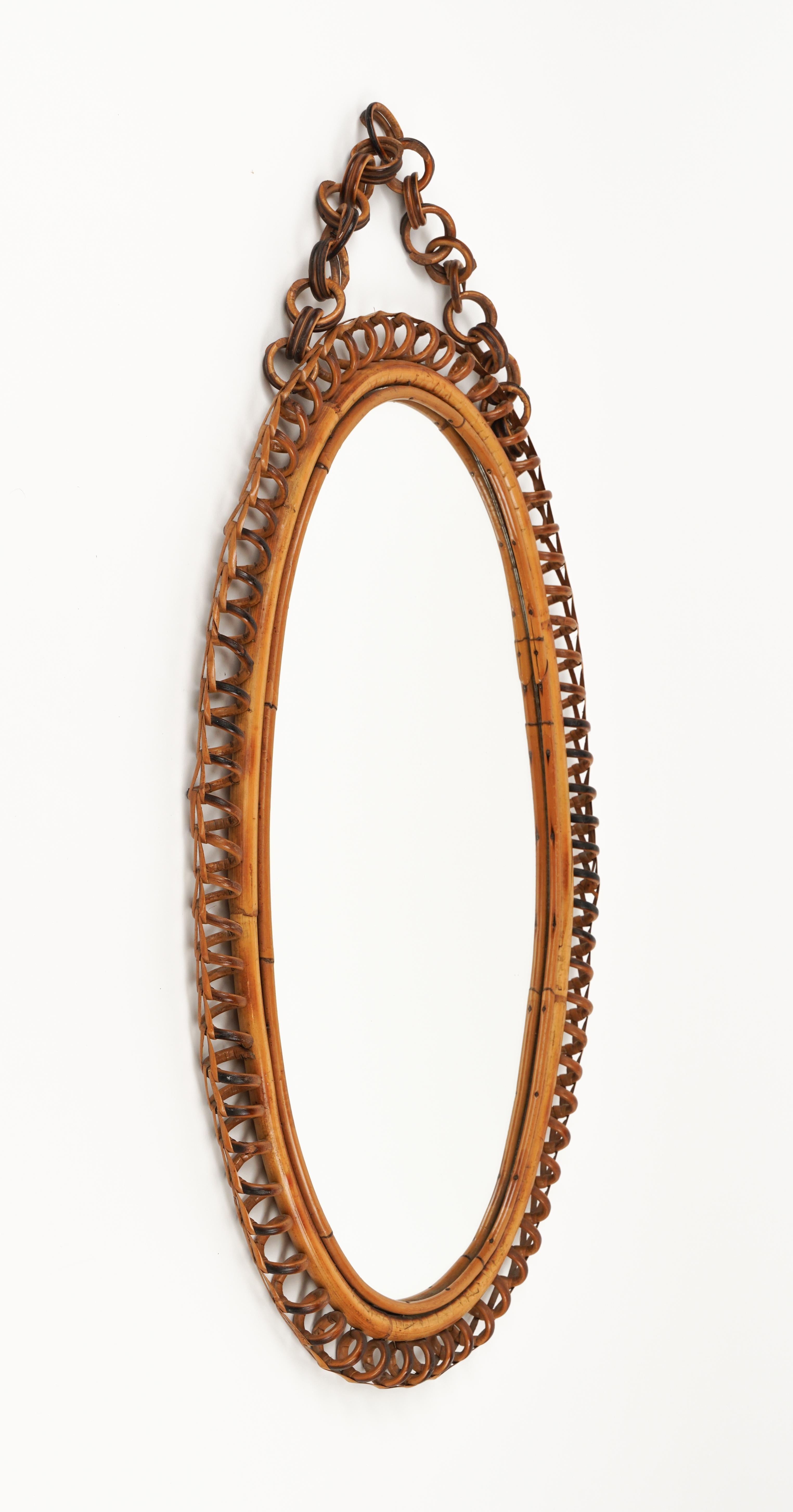 Midcentury beautiful oval wall mirror with chain in bamboo and rattan in the style of Italian design Franco Albini.  

Made in Italy in the 1960s.  

A highly decorative mirror.  

Dimensions without chain: 
Height 68 cm. 
Width 40cm. 
Depth 3cm.