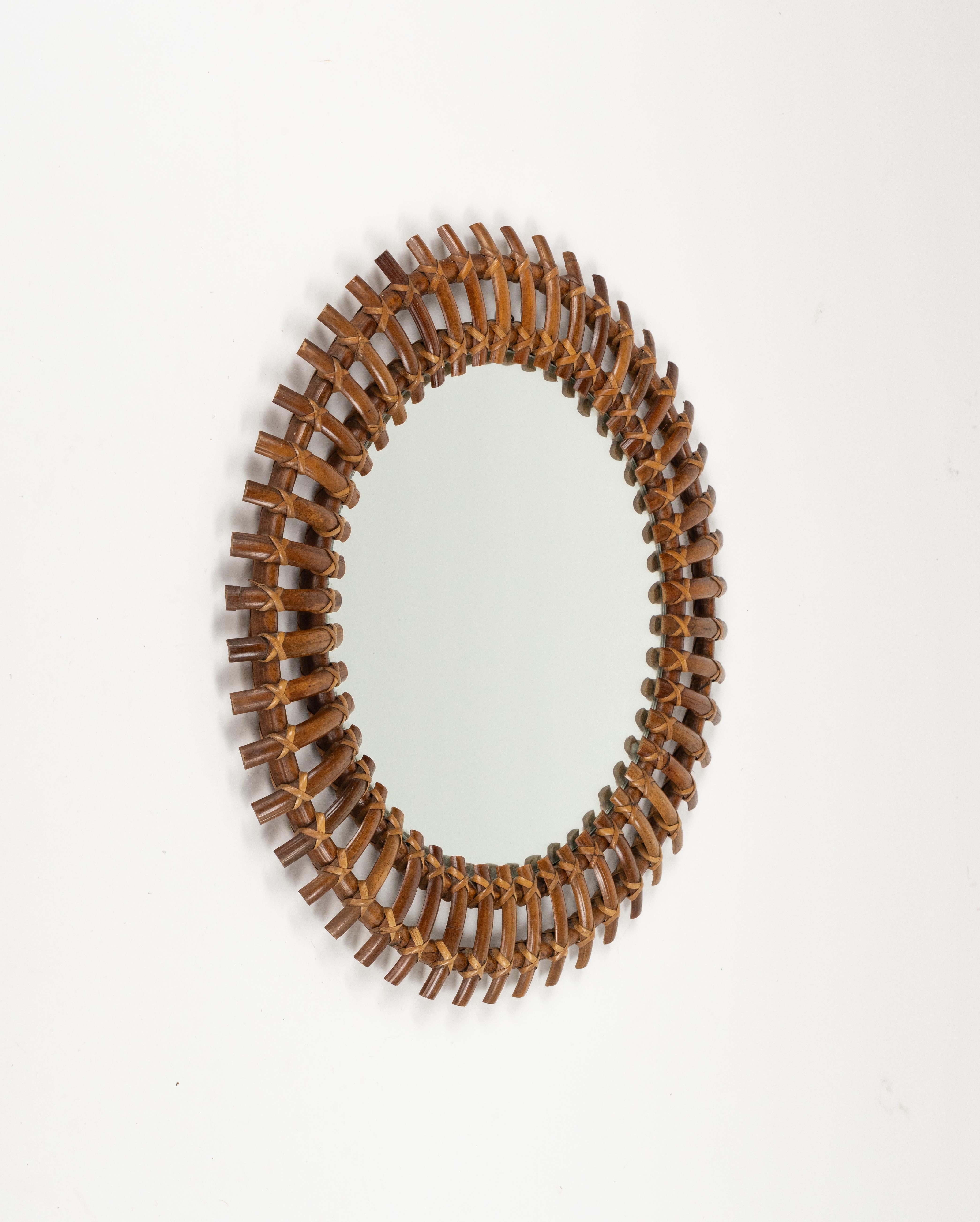 Midcentury beautiful sunburst round wall mirror in bamboo and rattan.   

Made in Italy in the 1960s.