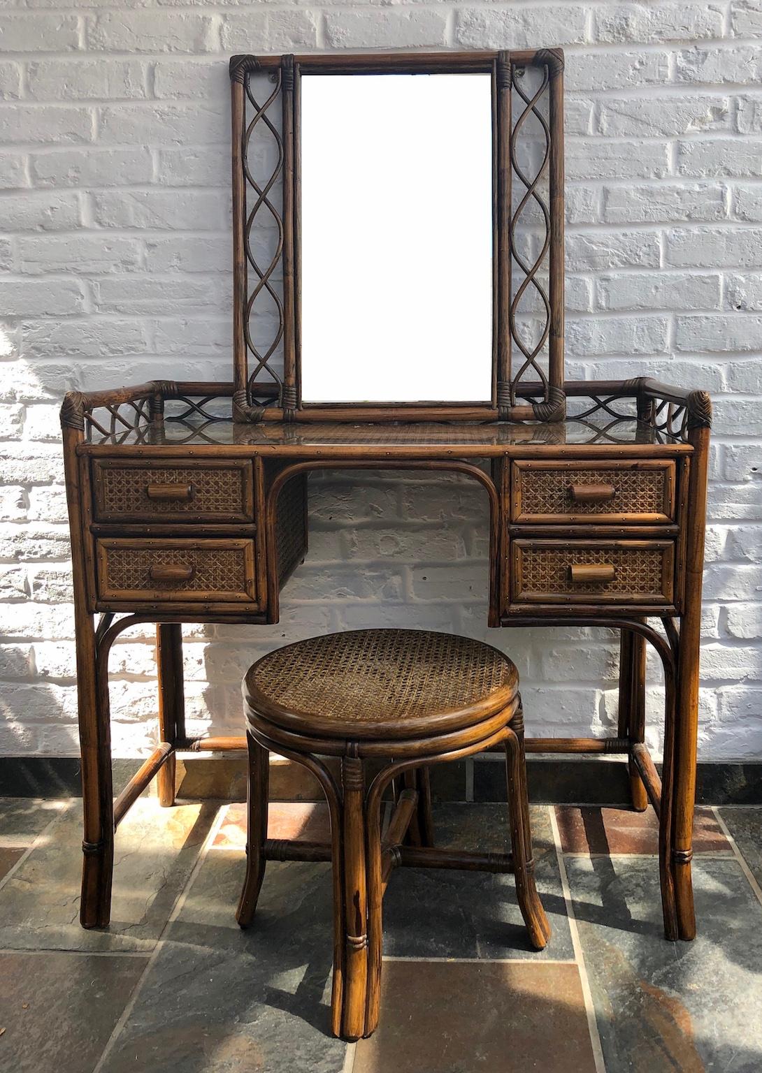 Midcentury rattan cane dressing table or small desk, stool and mirror set, England, 1970s

This is a beautiful set consisting of a dressing table or small desk, matching stool and wall mirror. 
Made by English company ‘Angraves of Leicester’, who