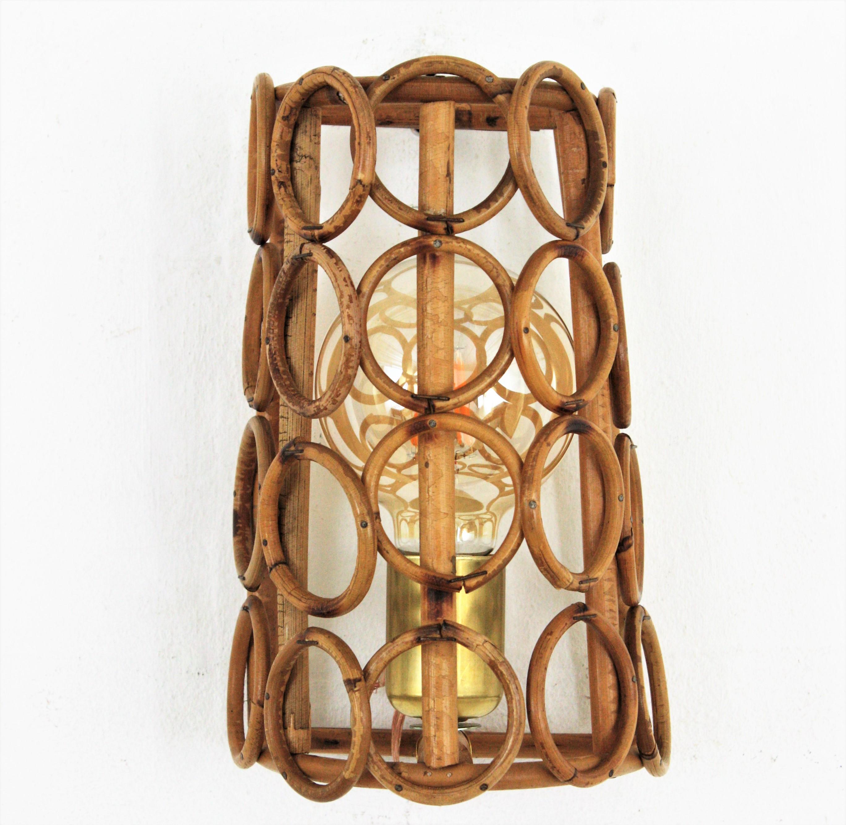 Wall sconce in rattan. France, 1960s.
This French Riviera wall light has a clean design with rattan rings. We have added a brass cover to hide the bulb holder.
It will be a fresh addition to any beach house, countryside house or urbn appartment