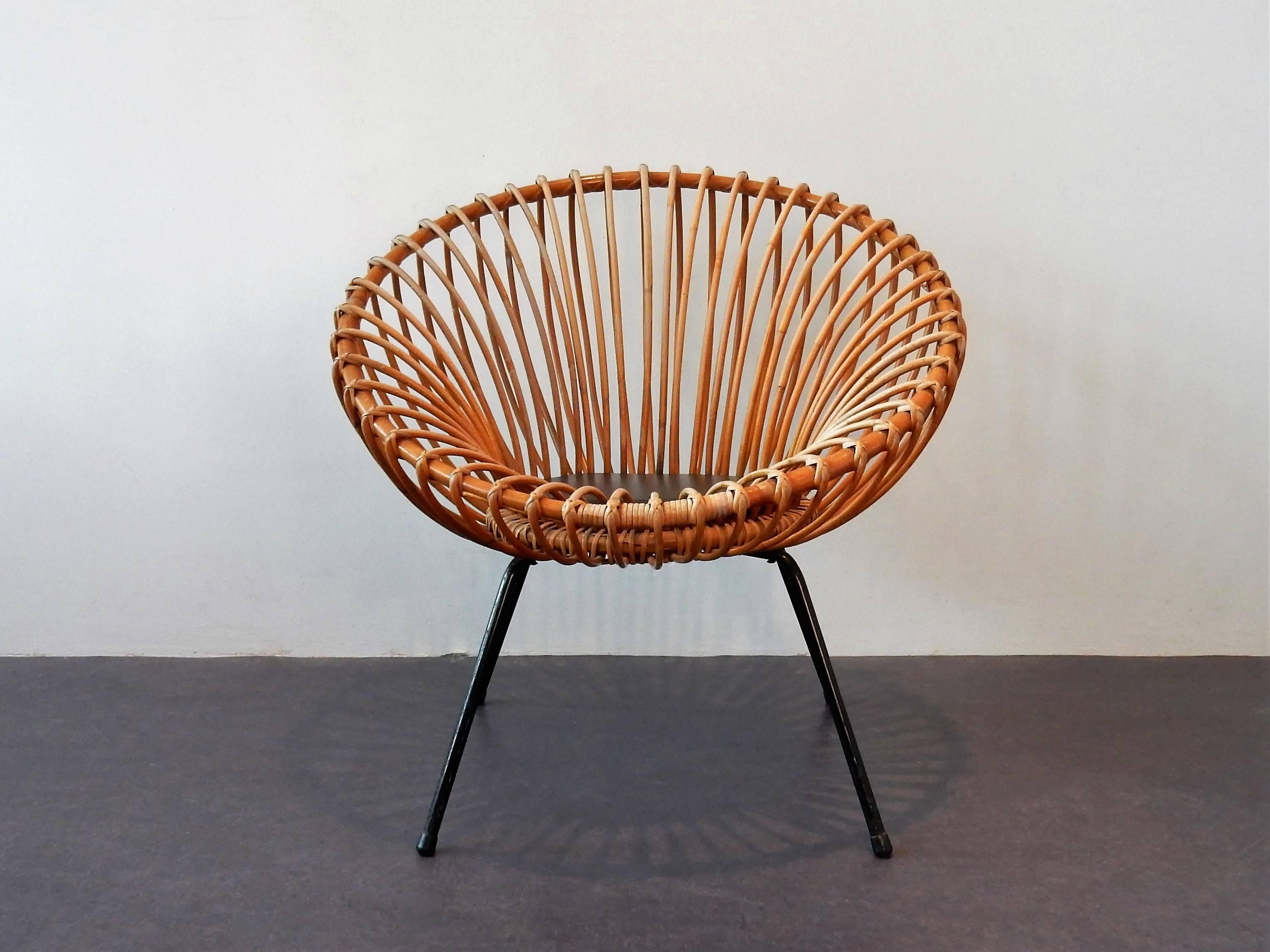 This is a very nice rattan scoop chair with a metal frame and a black faux leather circular seat pad. The chair is in the style of Rohé and Italian designer Franco Albini. It is in a very good condition considering age and use. Some signs of age and