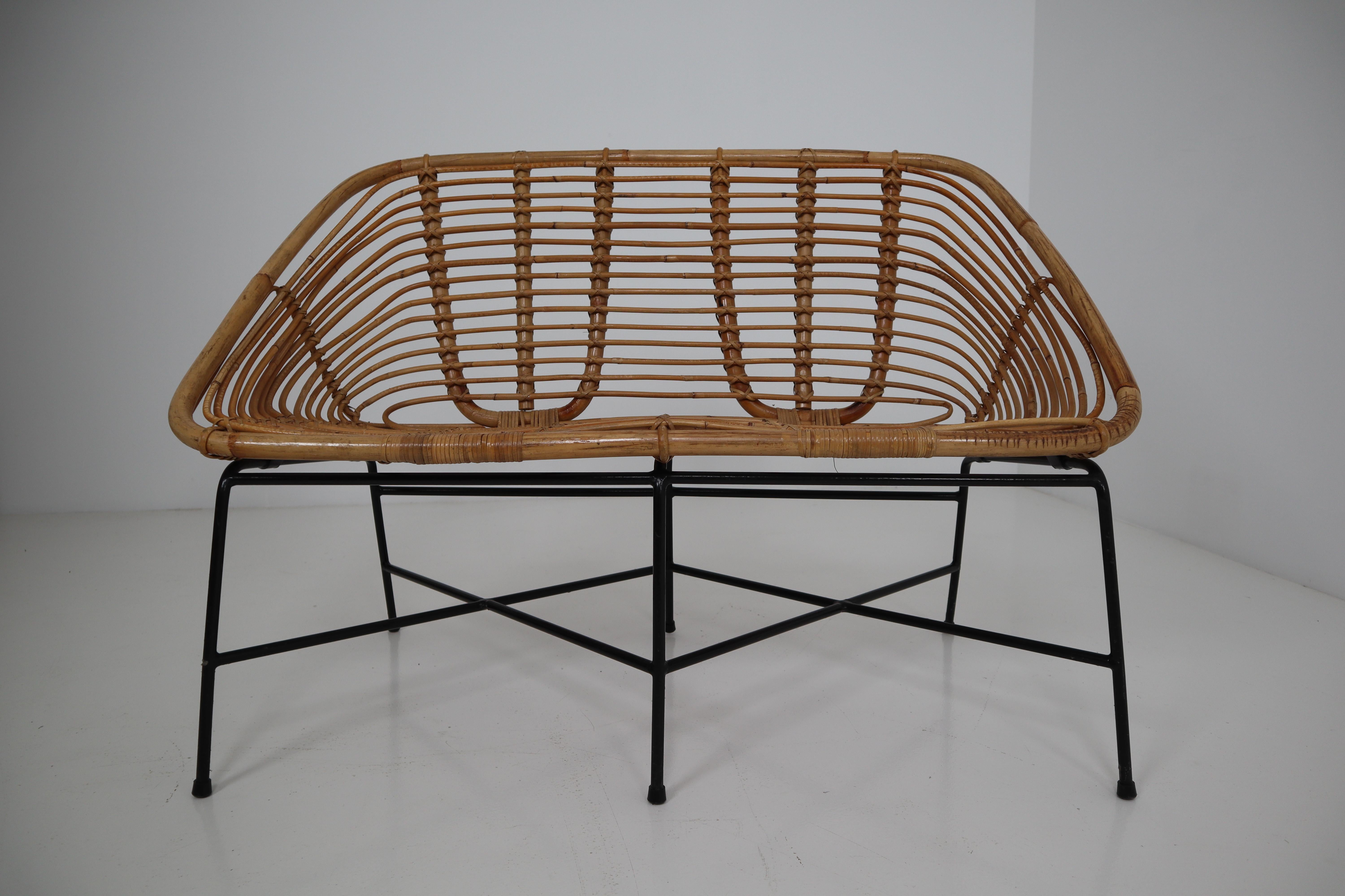 Elegant Italian rattan, wicker and iron settee. Rattan in excellent condition. The frame is made of black lacquered steel. They are comfortable to sit in and create an inviting sitting experience. In very good vintage condition with light wear and