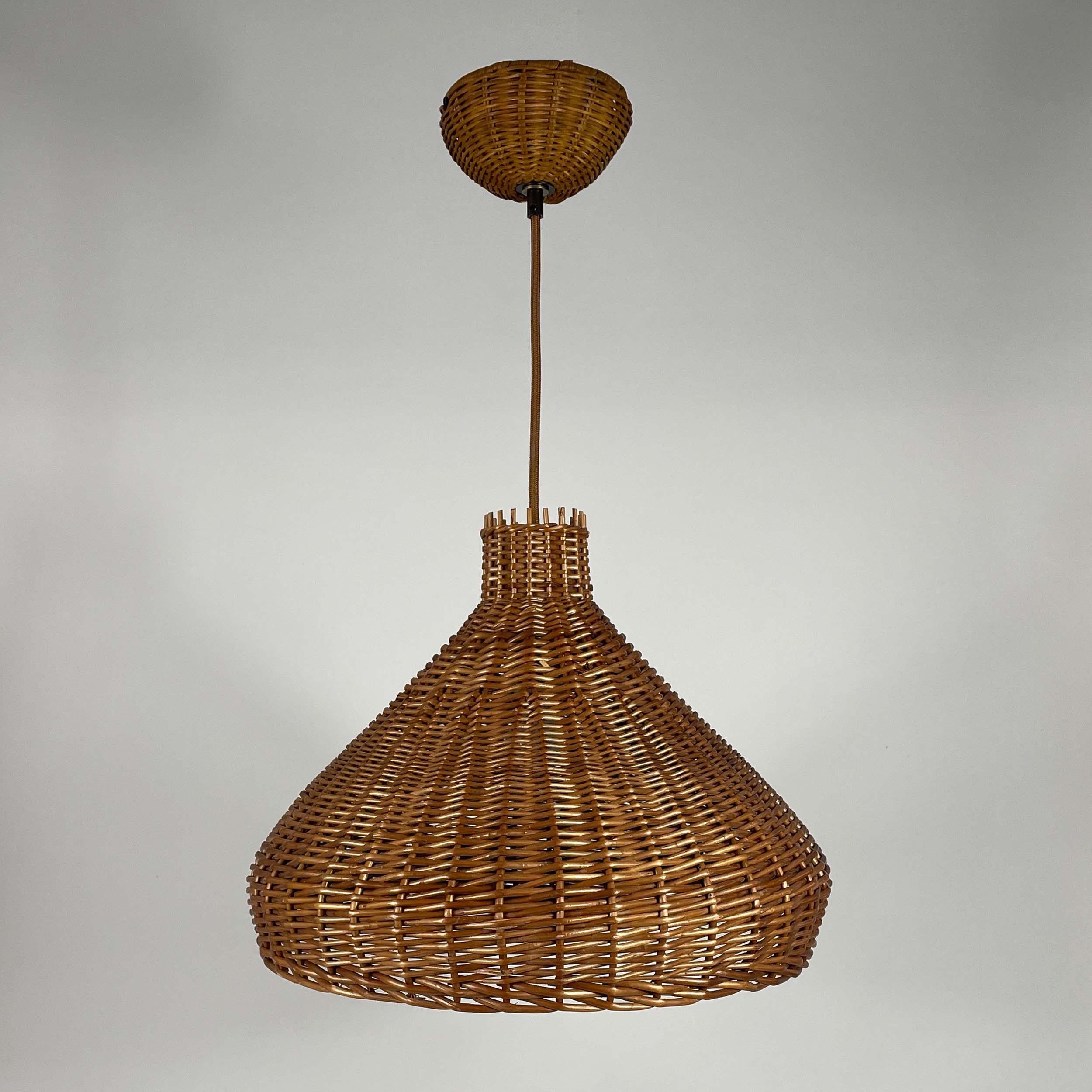 This rattan pendant or suspension light was designed and manufactured in Sweden in the 1960s. It features a large tulip shaped lampshade, brown fabric cord and a rattan canopy.

The light has been rewired for use in US and any other country of the