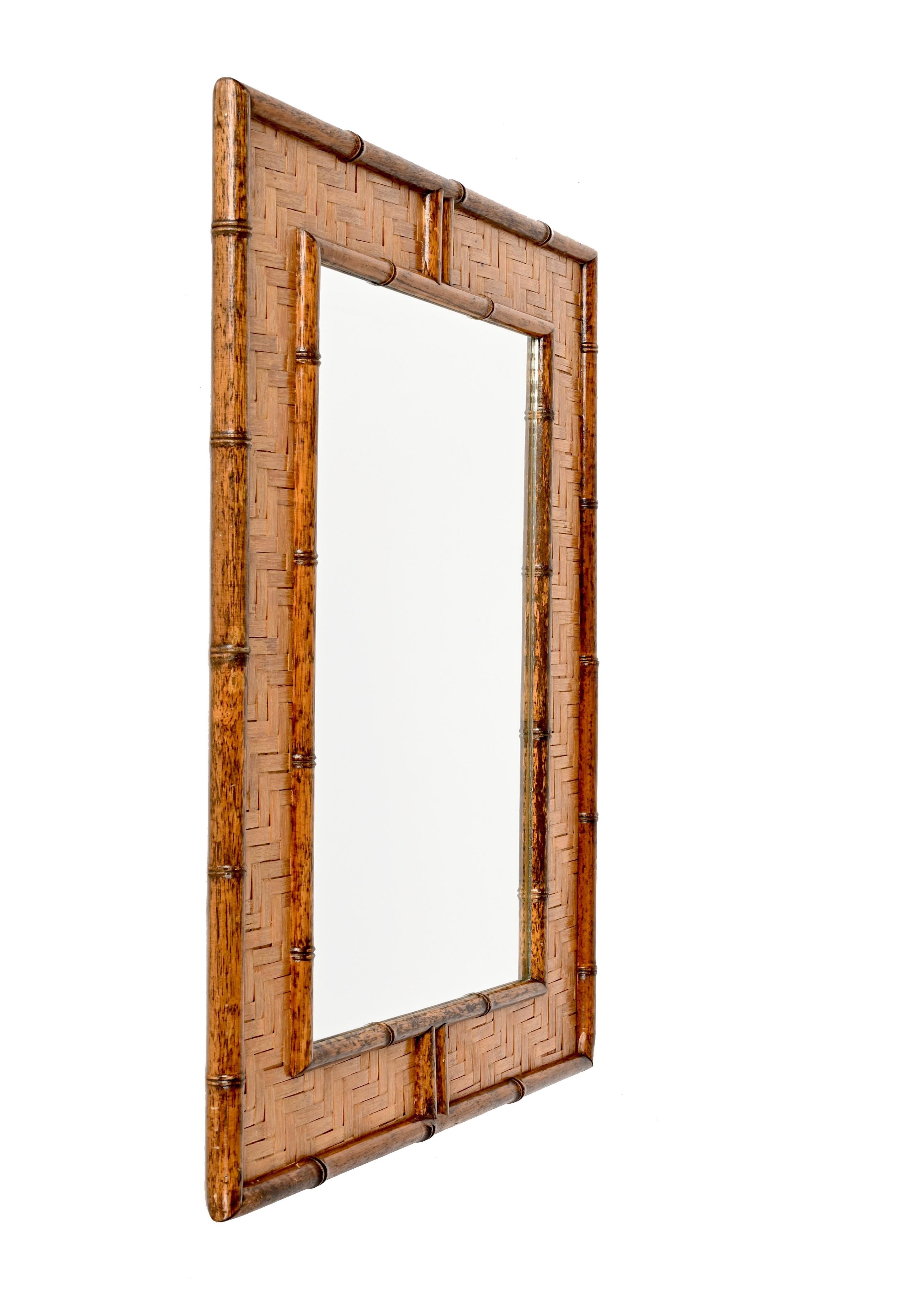 Astonishing midcentury rectangular bamboo cane and woven wicker mirror. This fantastic piece was designed in Italy during the 1960s.

The item is unique thanks to its fantastic frame, made of straight lines give bythe external and internal bamboo