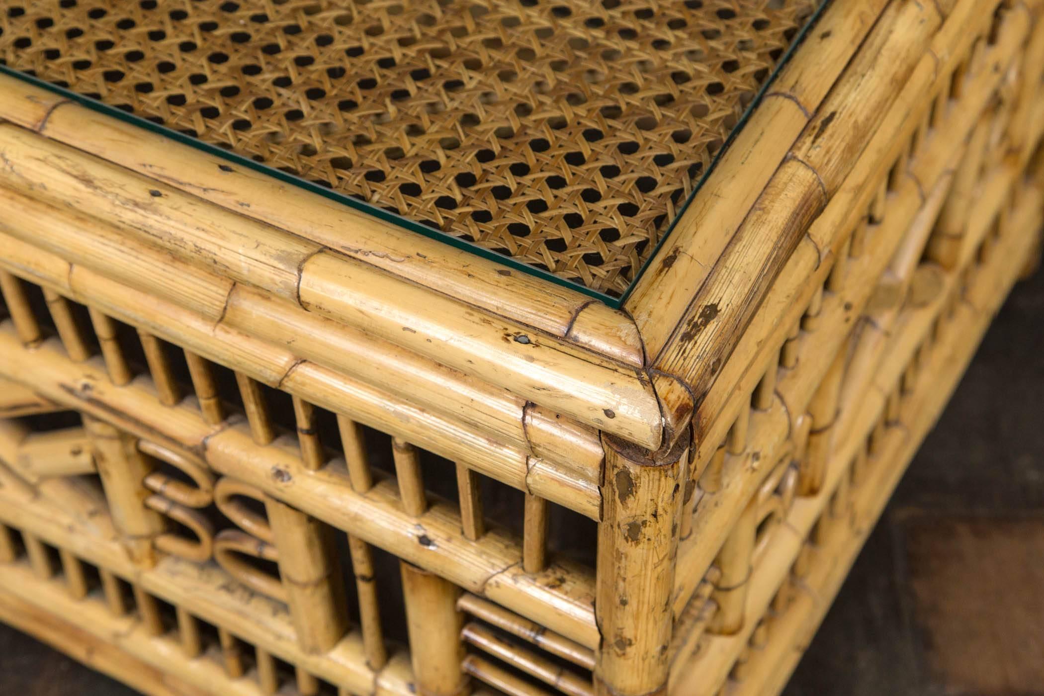 1960s bamboo coffee table, intricate design. Lovely faded finish. Caned top with glass. Stylish and sturdy.
 