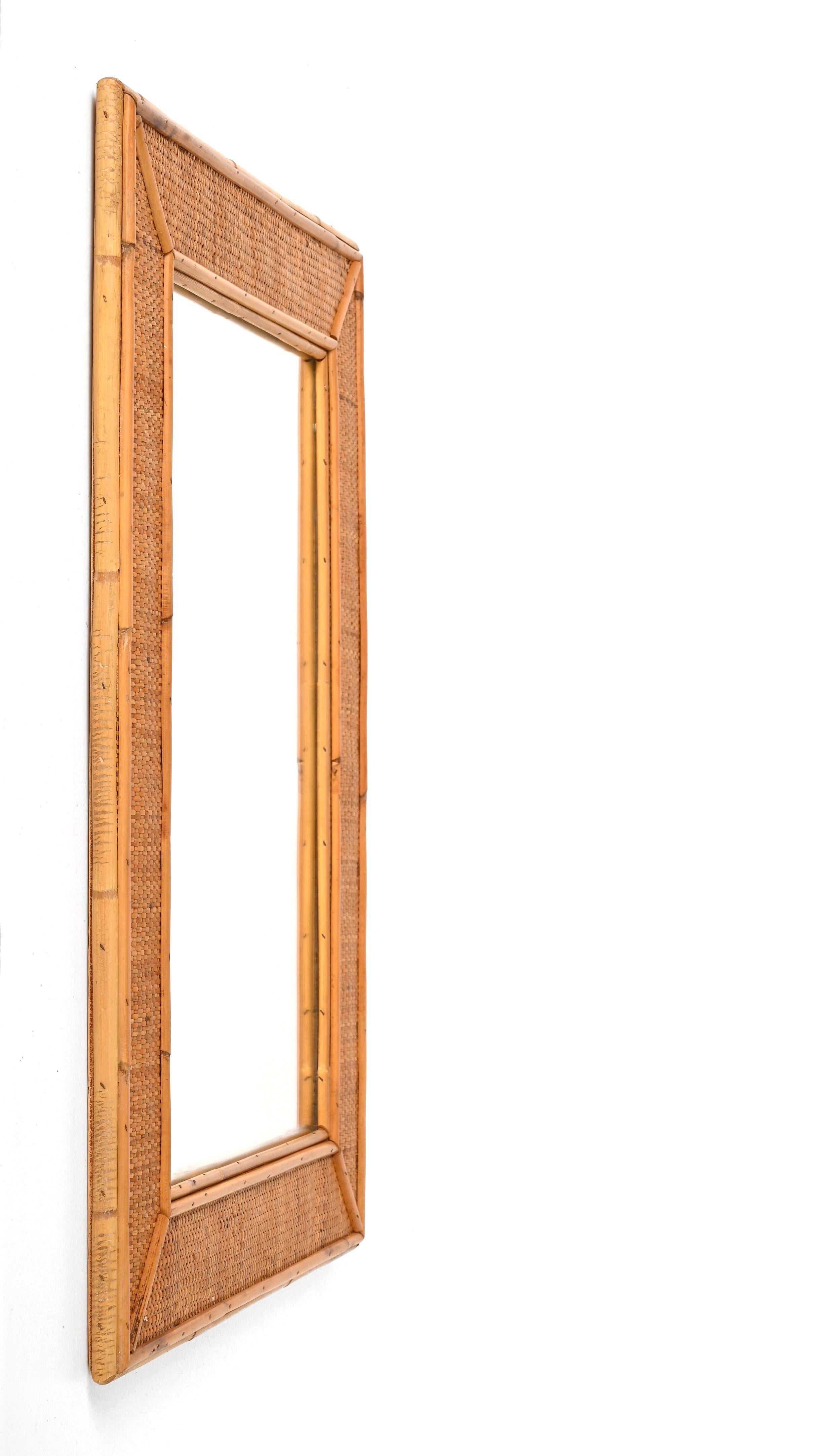 Spectacular midcentury rectangular bamboo and woven wicker mirror. This outstanding item was produced in Italy during the 1970s.

This piece is incredible thanks to its complex frame: it has an internal part made of small bamboo canes, the central