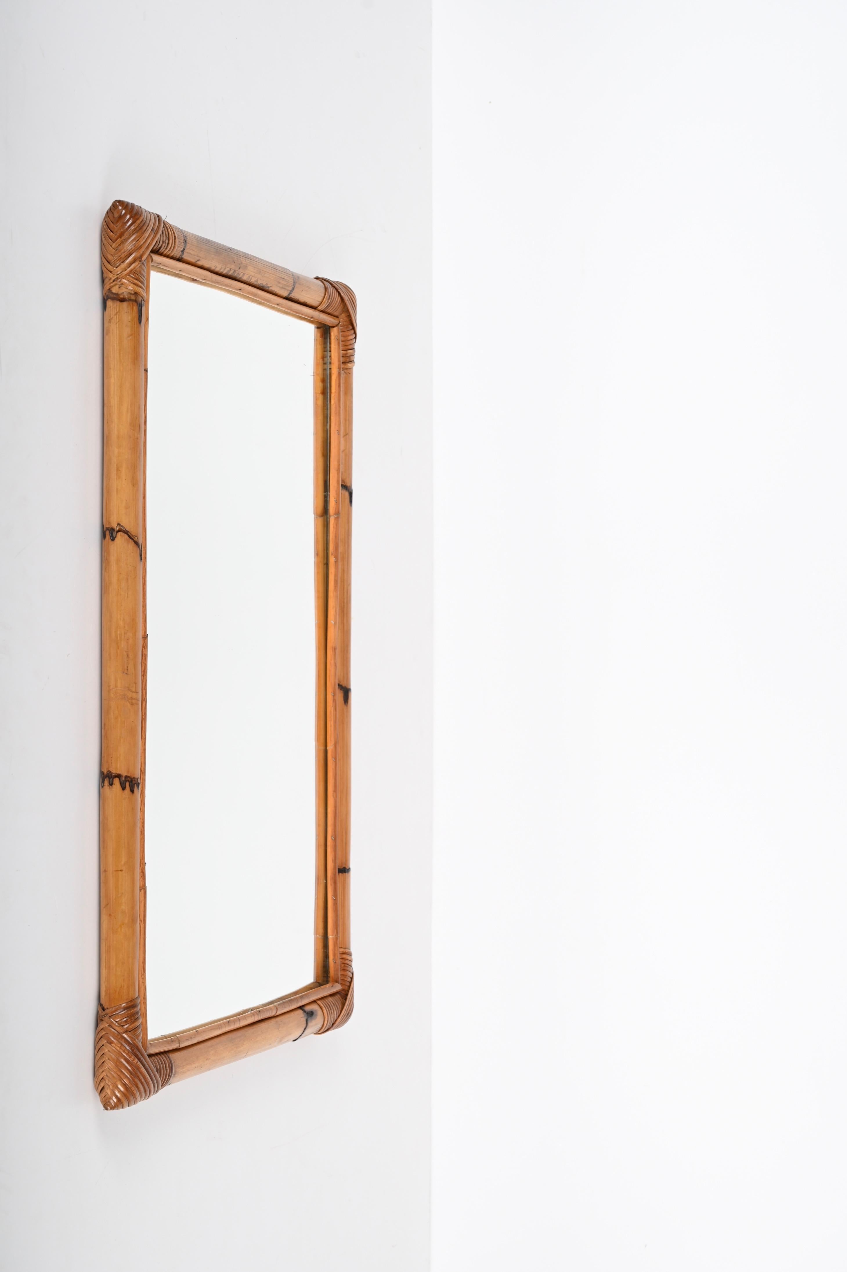 Marvellous midcentury rectangular mirror with double bamboo cane frame. This fantastic item was produced in Italy during the 1970s.

This magnificent piece is fantastic thanks to the way the straight bamboo lines with the mirror are simply
