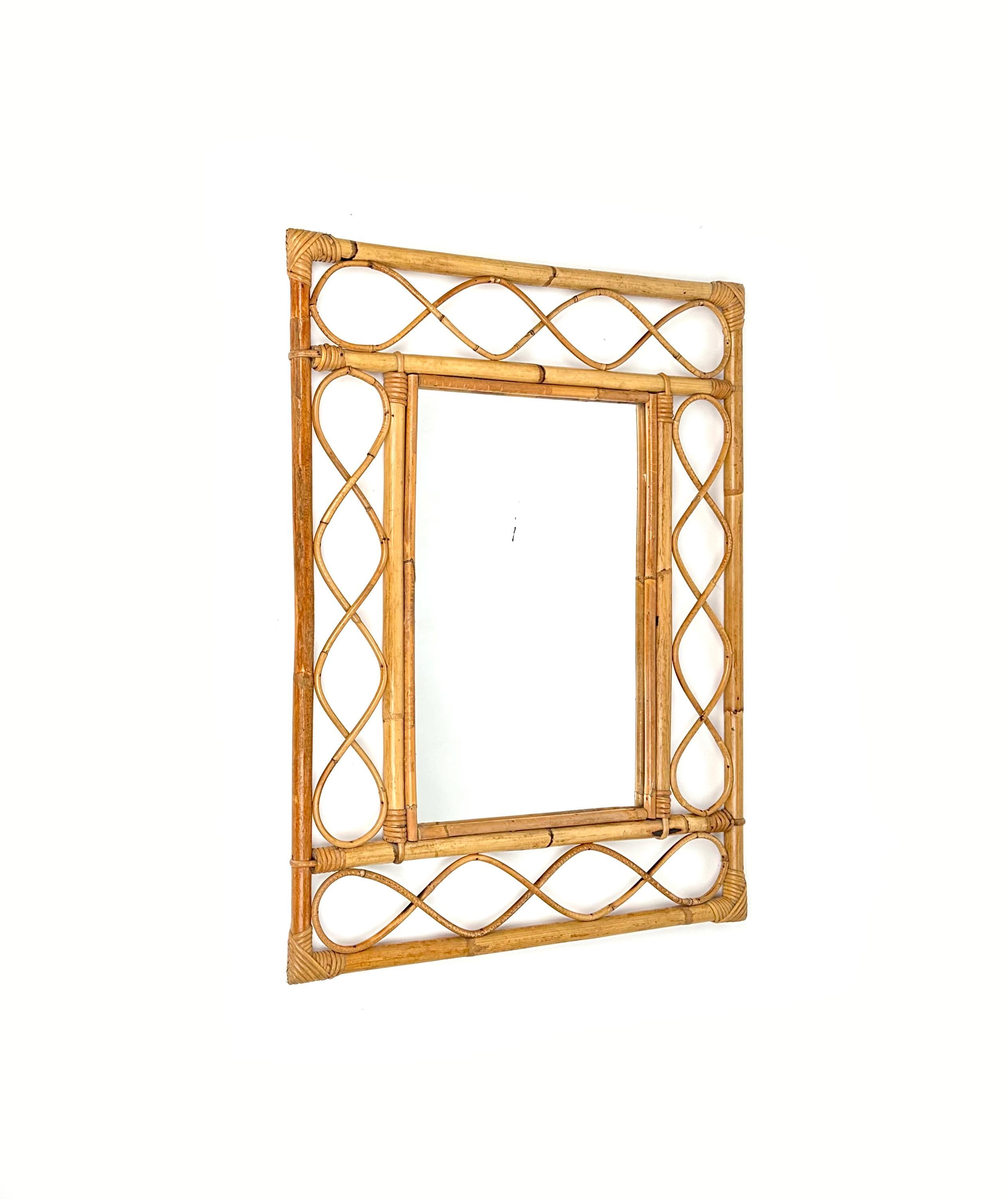 Midcentury Rectangular mirror in bamboo and rattan.

Made in Italy in the 1960s.

This is an Asian-inspired design with inner and outer frames connected by geometric shapes of rattan cane. The corners are lashed together and protected with