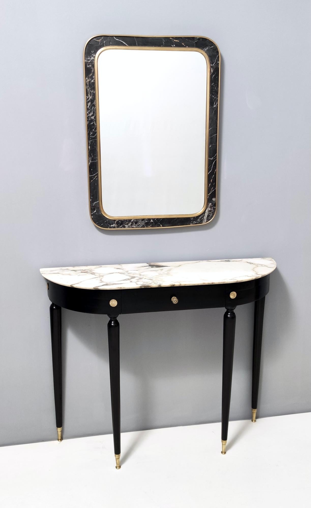 Italy, 1960s.
This mirror features a brass and black Portoro marble frame. 
It is a vintage piece, therefore it might show slight traces of use, but it can be considered as in excellent original condition and ready to become a piece in a home.