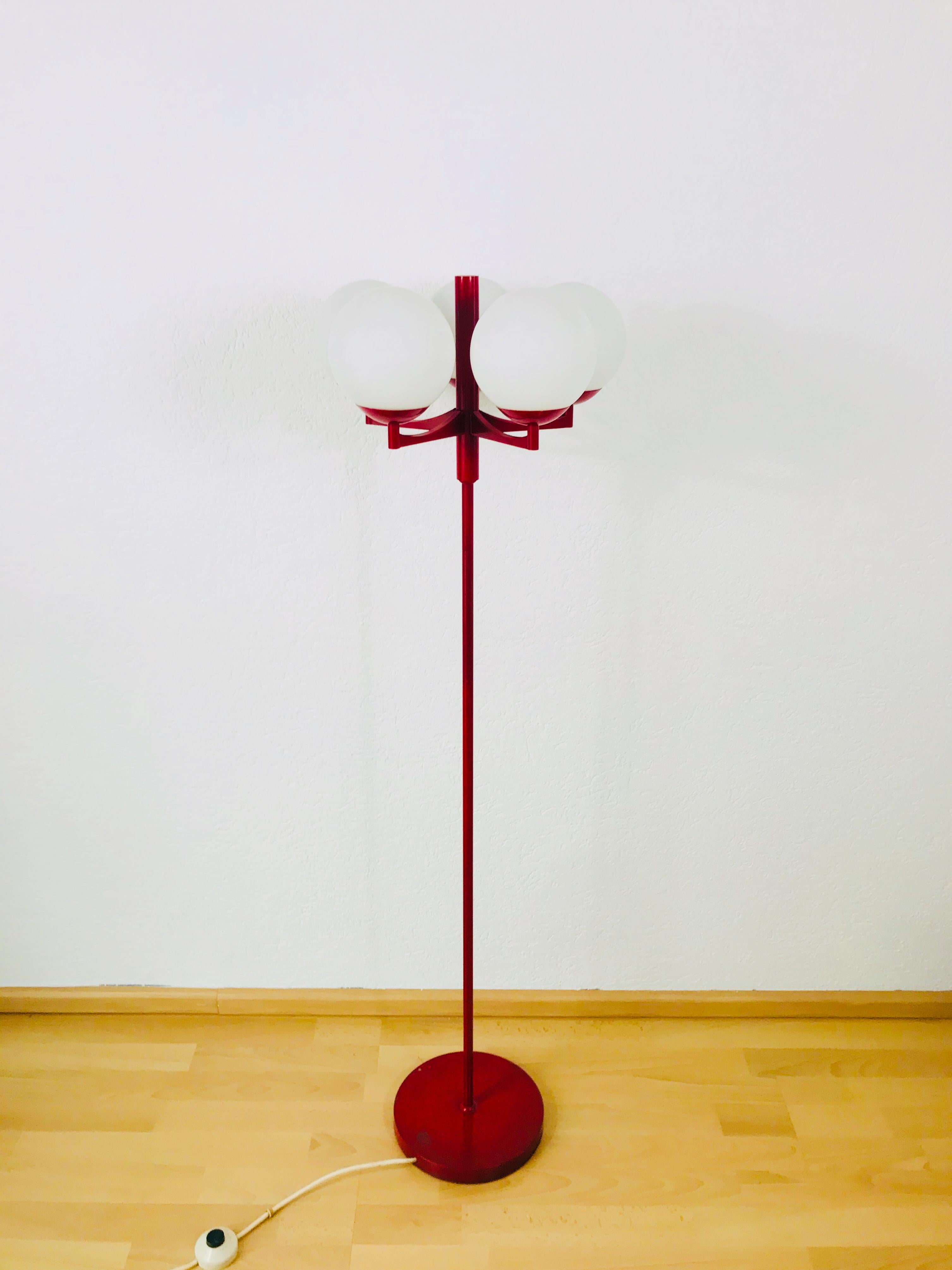 A midcentury floor lamp attributed to Kaiser made in Germany in the 1960s. It is fascinating with its Space Age design and five ball shaped opaque balls. The bottom of the light is made of full metal. The bar is also made of metal including the