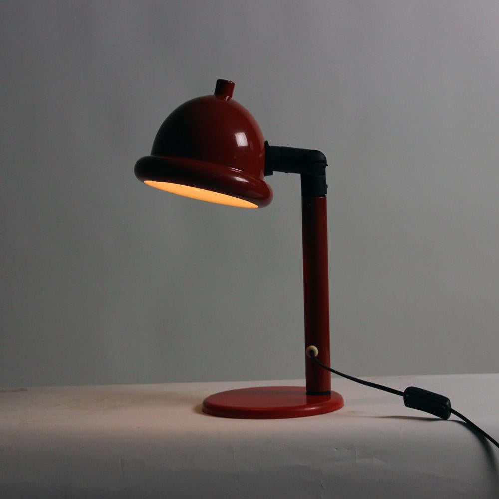 Beautiful midcentury table lamp with elegant design. Produced in Czechoslovakia in 1960s. The lamp is fully made of red metal, in combination with black plastic details. Really nice color combination, as well as an interesting design. Typical