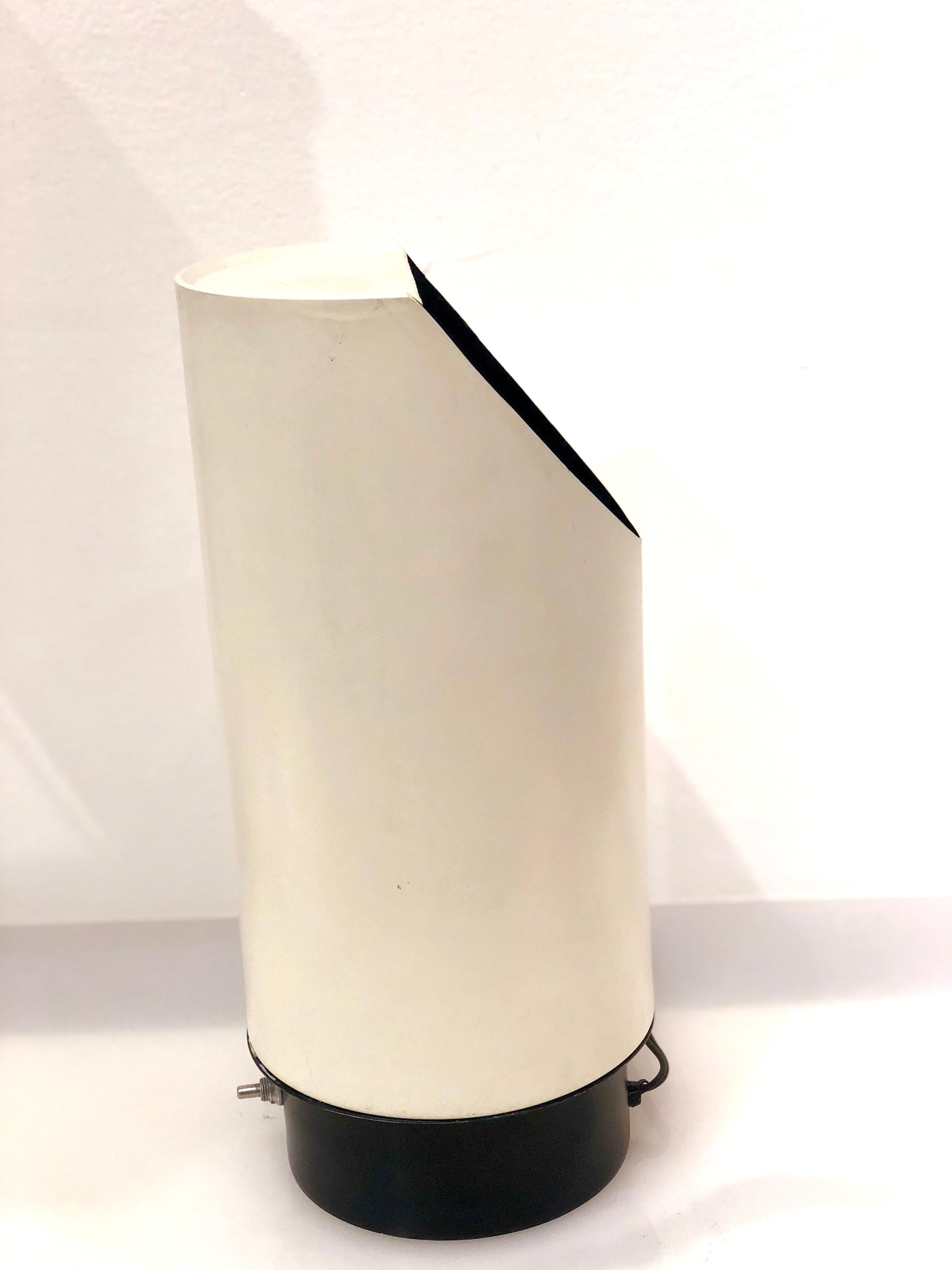 Belle lampe tubulaire à réflecteur, en finition mate émaillée blanche et base noire, en parfait état l'ampoule se projette vers le haut et un réflecteur, projette la lumière à l'extérieur, dans un intérieur noir.