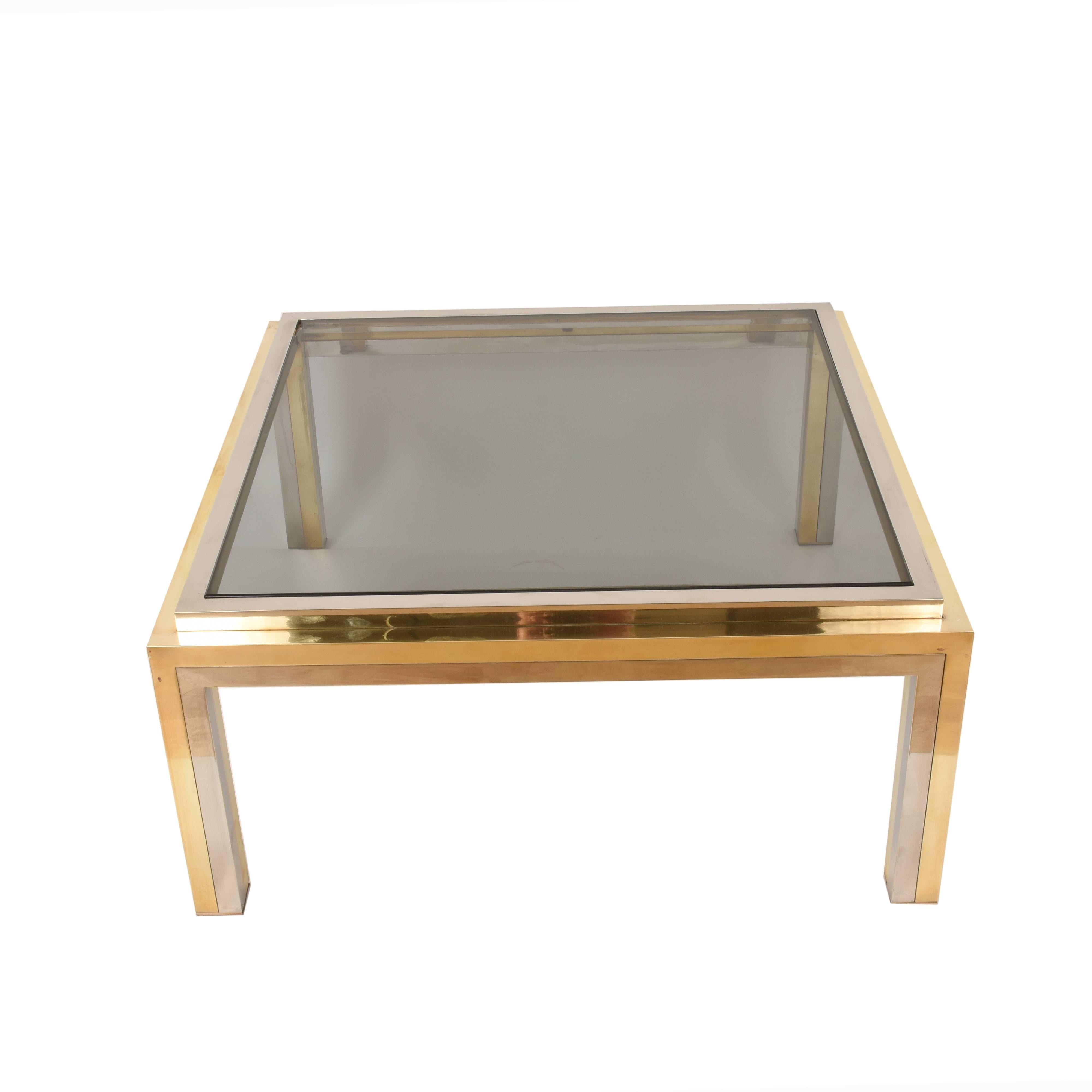 Elegant midcentury smoked glass, brass and chrome squared coffee table. This amazing piece was designed by Romeo Rega in Italy during the 1970s.

This coffee table, thanks to the chromed metal and brass the frame, and smoked glass in the middle is