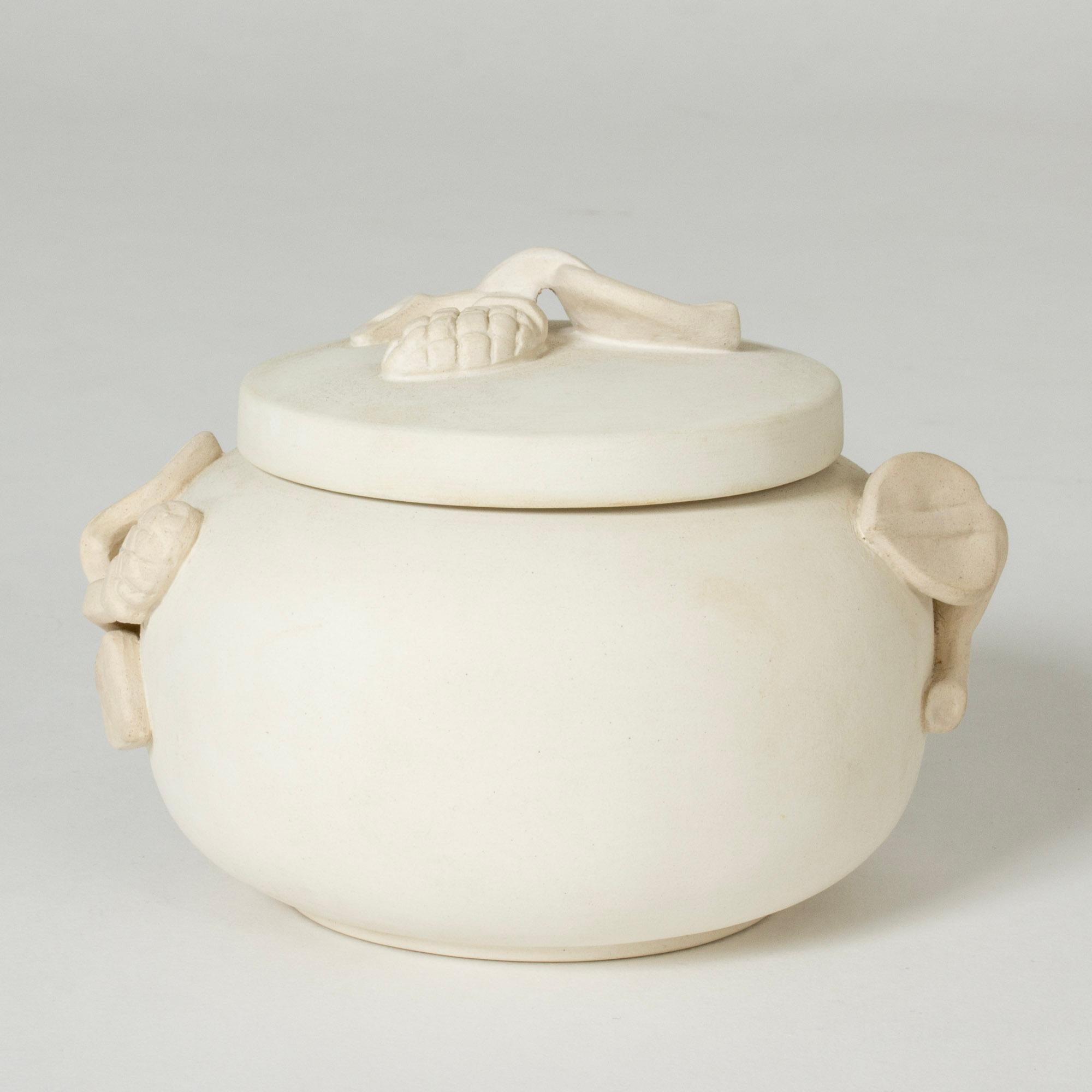 Beautiful “Relief” jar by Wilhelm Kåge, made in white, unglazed “Carrara” stoneware. Clean form with ornaments of twigs on the sides and lid.