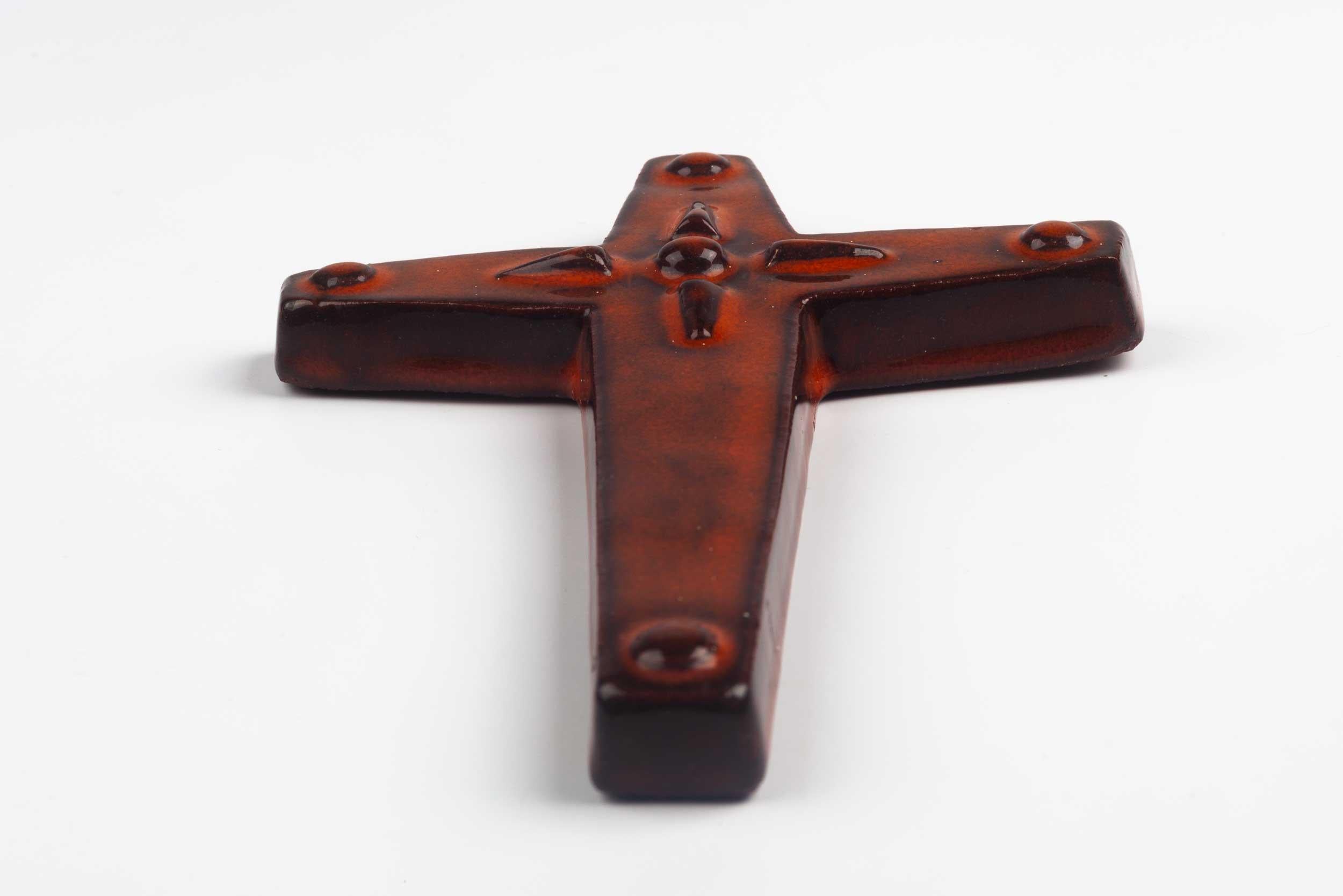 Midcentury European wall cross in glazed, hand painted ceramic with decorative volume. From a large collection of vintage crosses handmade by Flemish artisans. 

From modernism to brutalism, the crosses in our collection range from being as