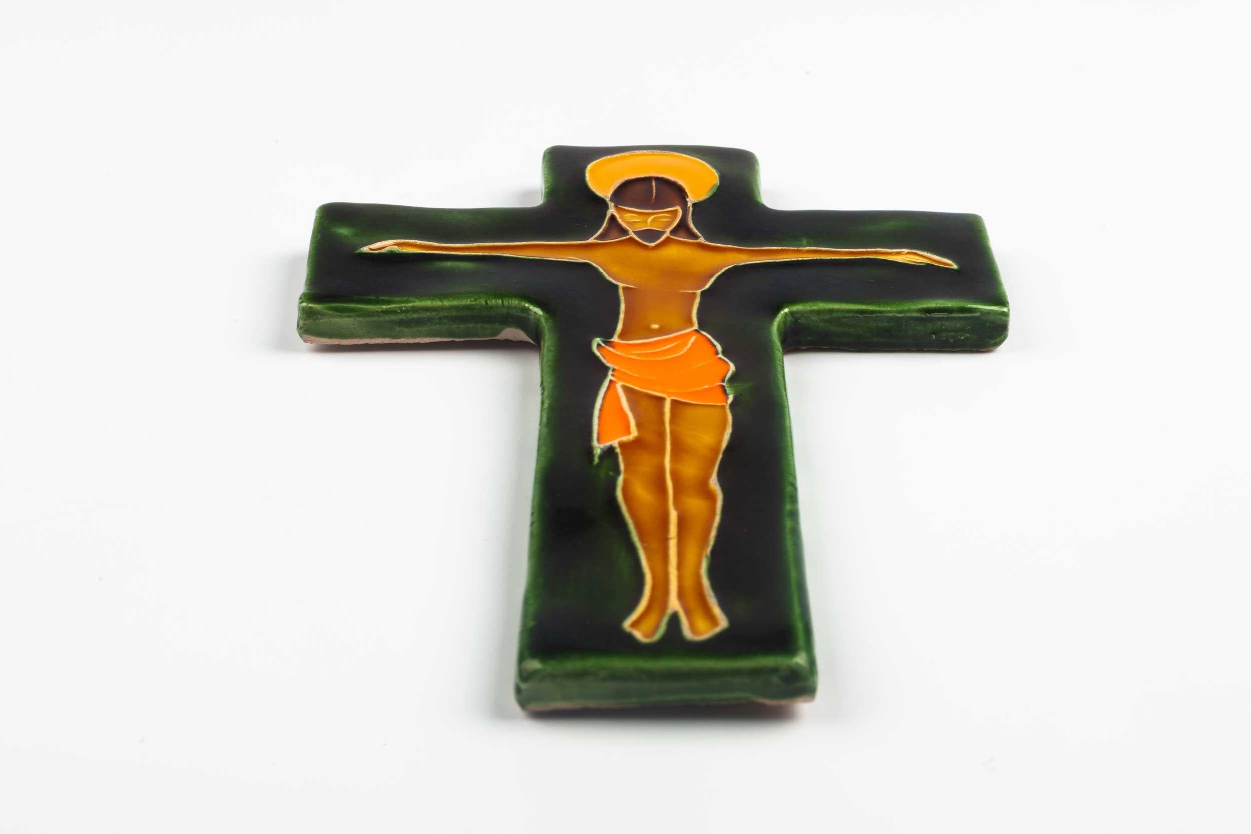 Midcentury European wall crucifix in glazed ceramic depicting stylistic Christ on green cross. From a large collection of vintage crosses handmade by Flemish artisans. 

From modernism to brutalism, the crosses in our collection range from being