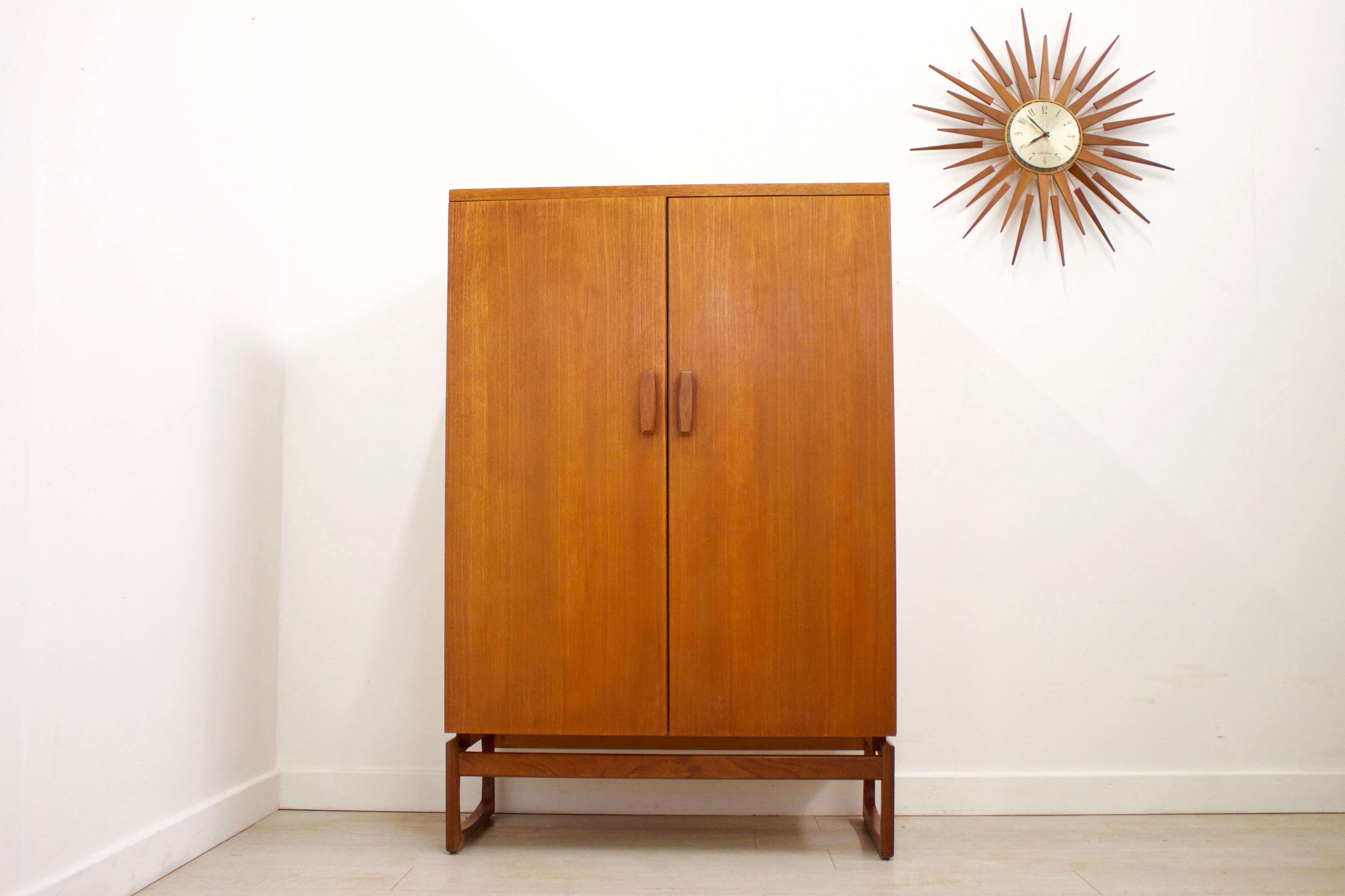 - Mid-Century Modern wardrobe.
- Made from Teak & Teak Veneer.
- Features a pull-out hanging rail to the left, and 2 drawers with 3 shelves on the right for ample storage.