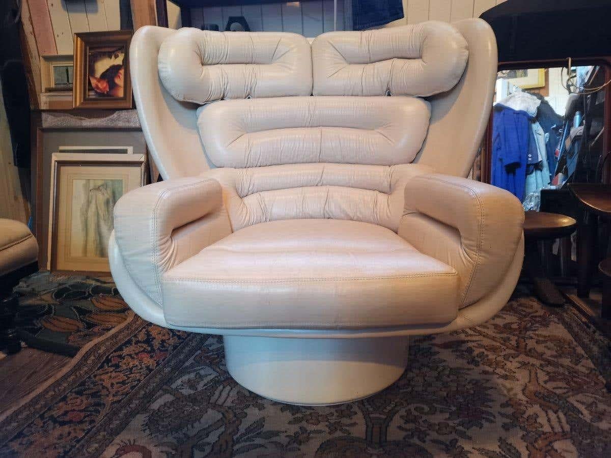 A midcentury revolving 'Elda' chair, designed by Joe Colombo for Comfort in 1963. This one was probably made in the 1970s-1980s.
Polyester fiberglass, shell, with cream leather upholstery. The cushions are fastened with metal hooks.
Measures:
