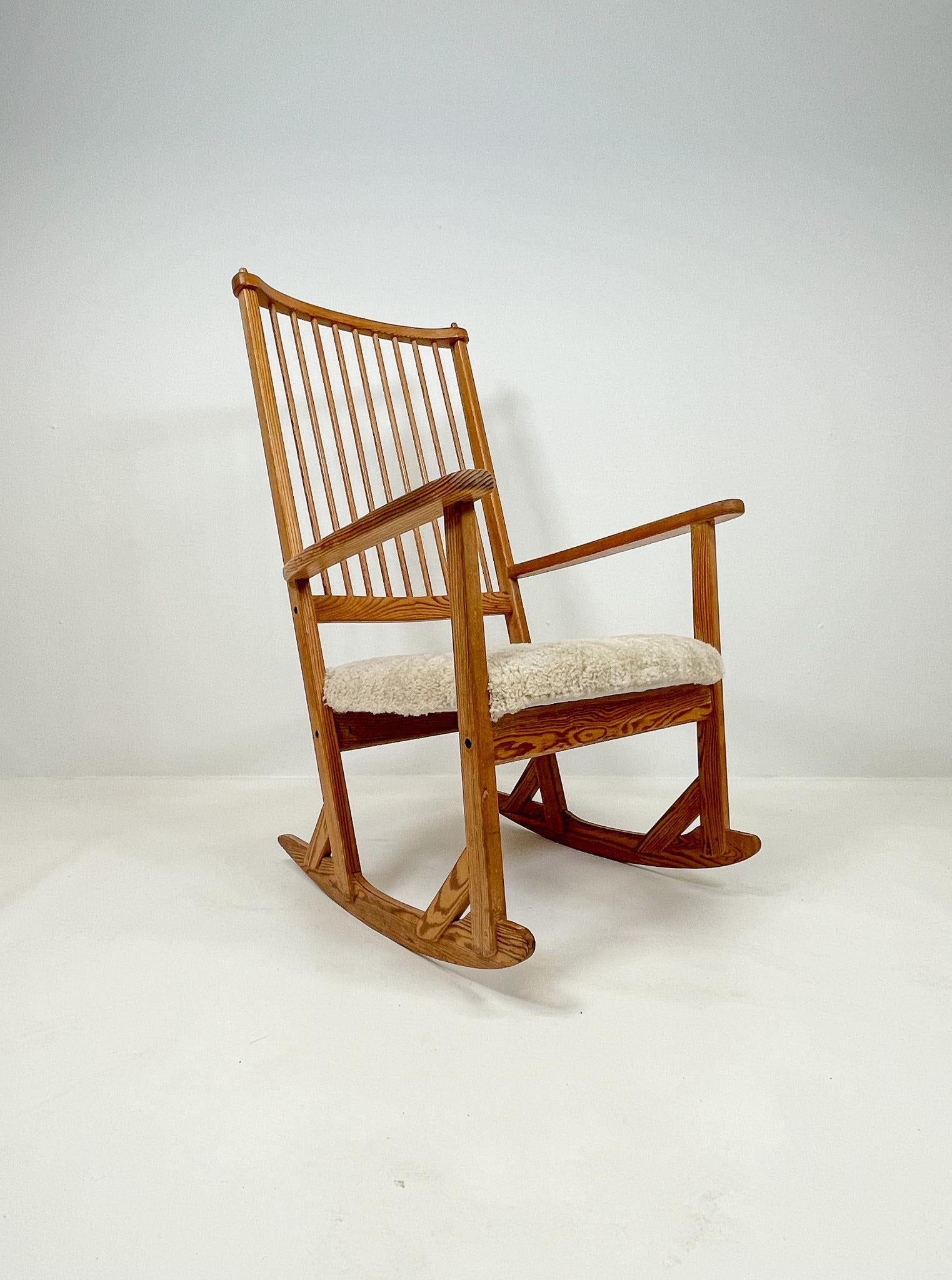 Cette chaise à bascule merveilleusement travaillée a été conçue par le célèbre designer suédois Yngve Ekström dans les années 1970 et produite par Swedese. Celui-ci est fabriqué en pin avec un siège nouvellement rembourré en peau de mouton. 

Bon