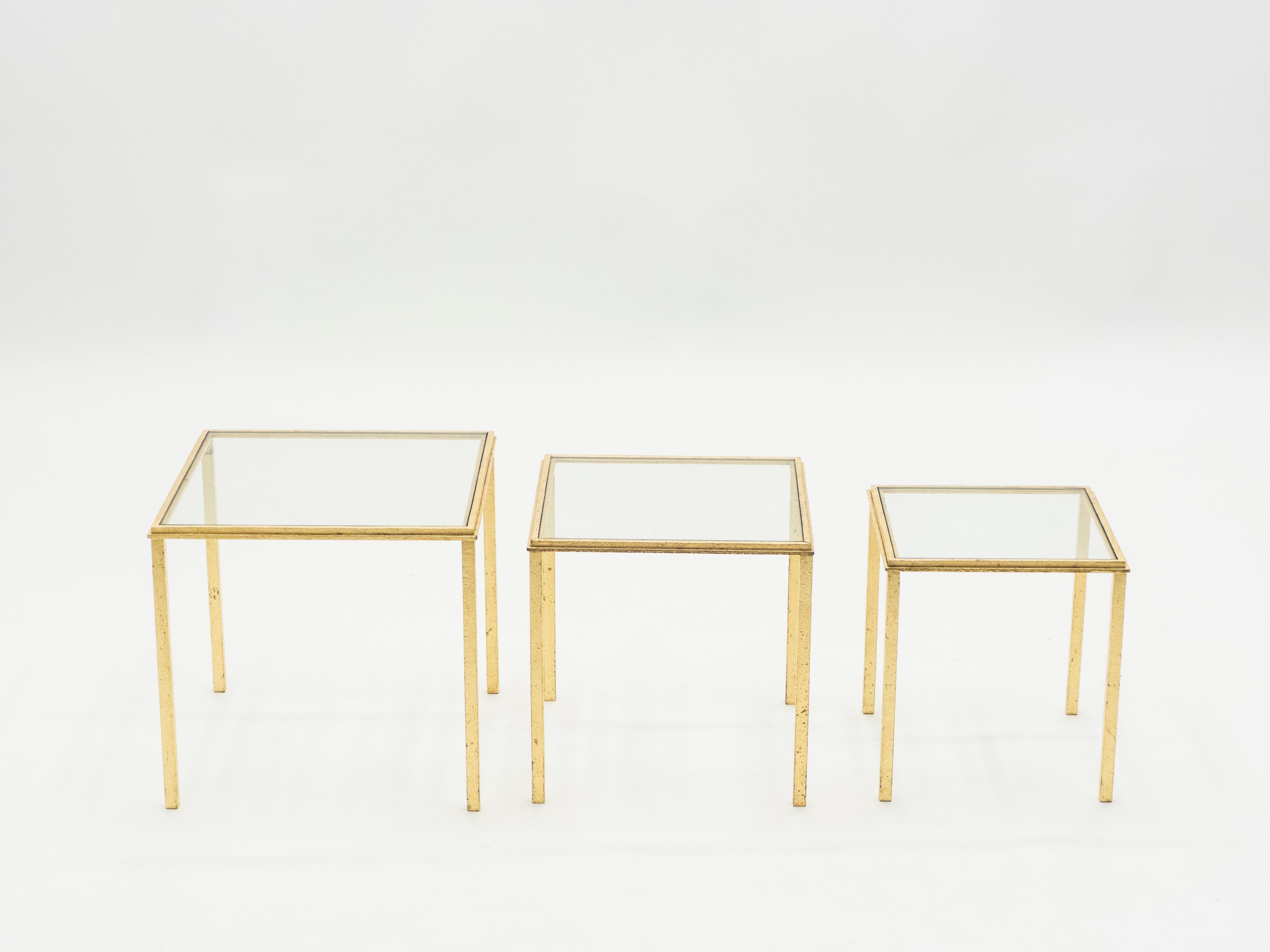 Simple lines point to this nesting tables midcentury roots. Designed by Roger and Robert Thibier, it features silky wrought iron legs that has been gilded with gold leaf for a gentle warm golden patina throughout the entire structure. Its symmetry,