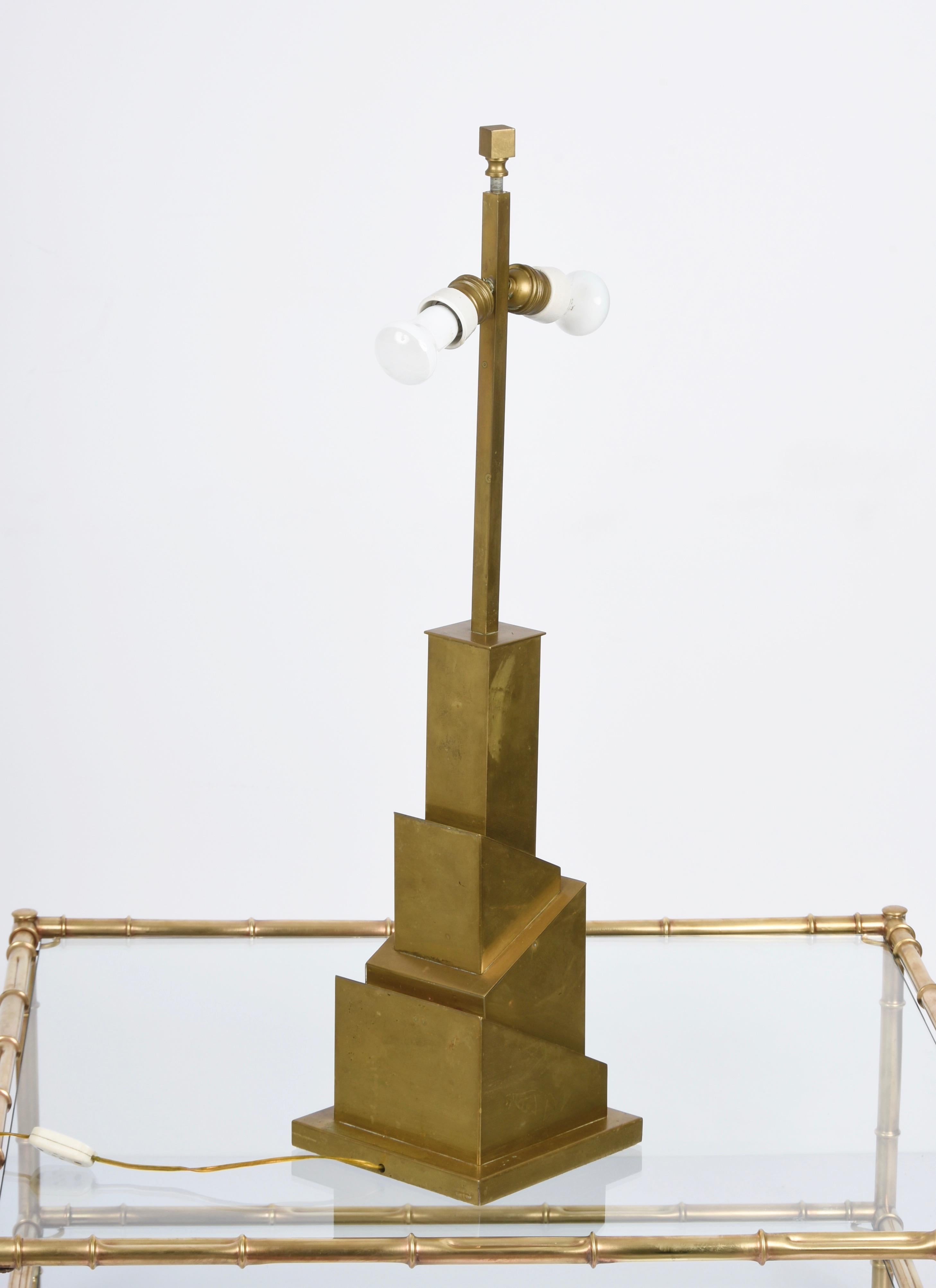 Amazing skyscraper-shaped midcentury brass table lamp. This fantastic piece was designed and signed by Romeo Rega in Italy during the 1970s. 

The lamp has its original brass and silk shade and it is in great vintage conditions.

The imaginative