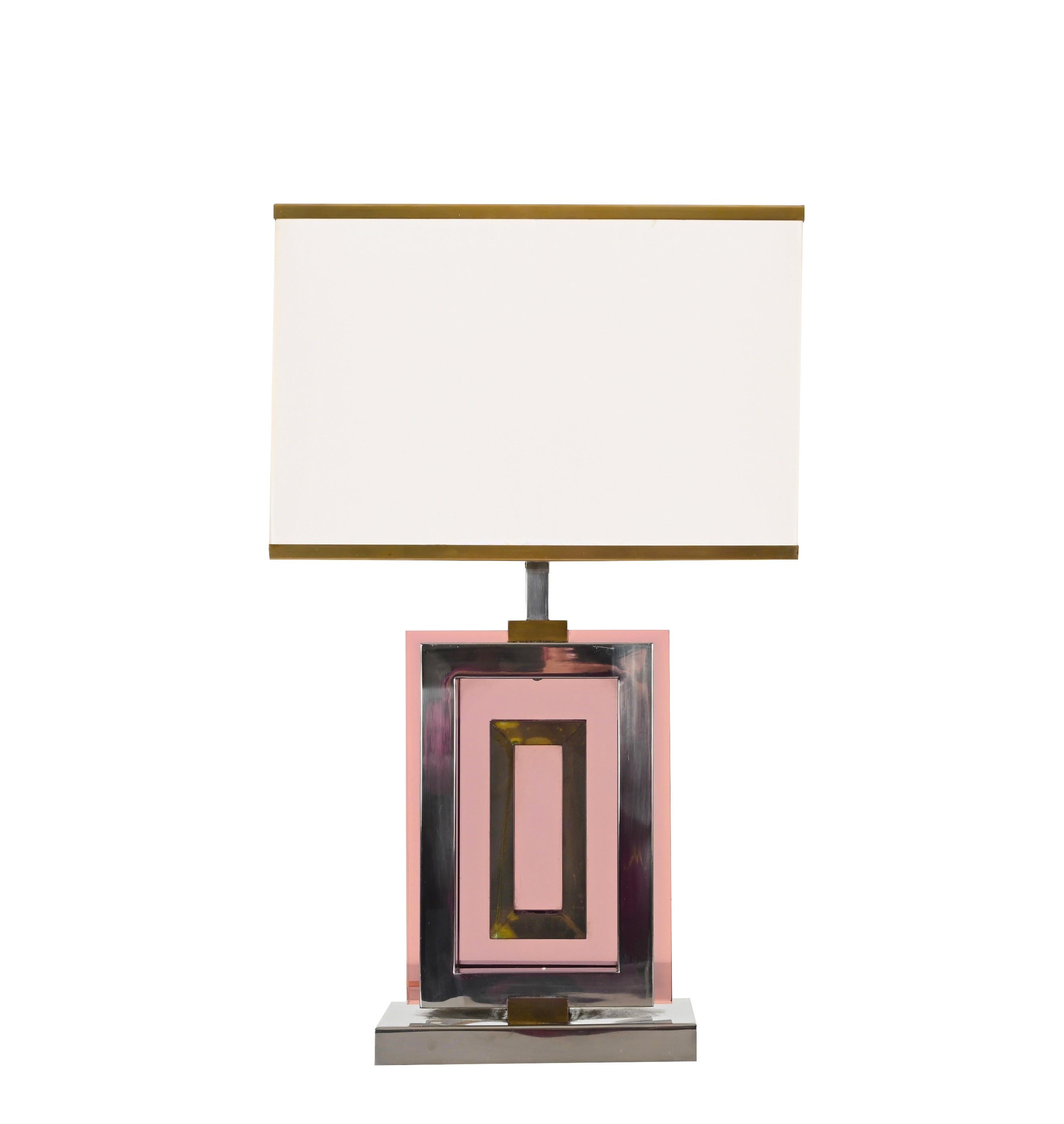 Étonnante lampe de table conçue par le designer romain Romeo Rega dans les années 70. Les matériaux utilisés sont le laiton chromé, le laiton doré et le perpex de couleur améthyste. 
La structure de cette lampe est incroyablement élégante avec une