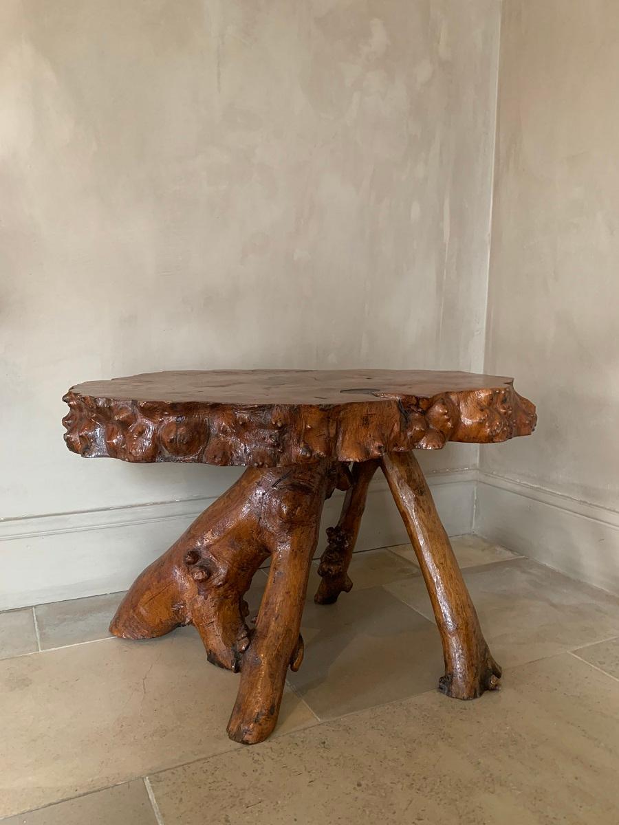 A great looking low root table. The organic feet in harmony with the natural top in one piece and with attractive small knots. No doubt this piece was made from the same tree by a skilled artisan.