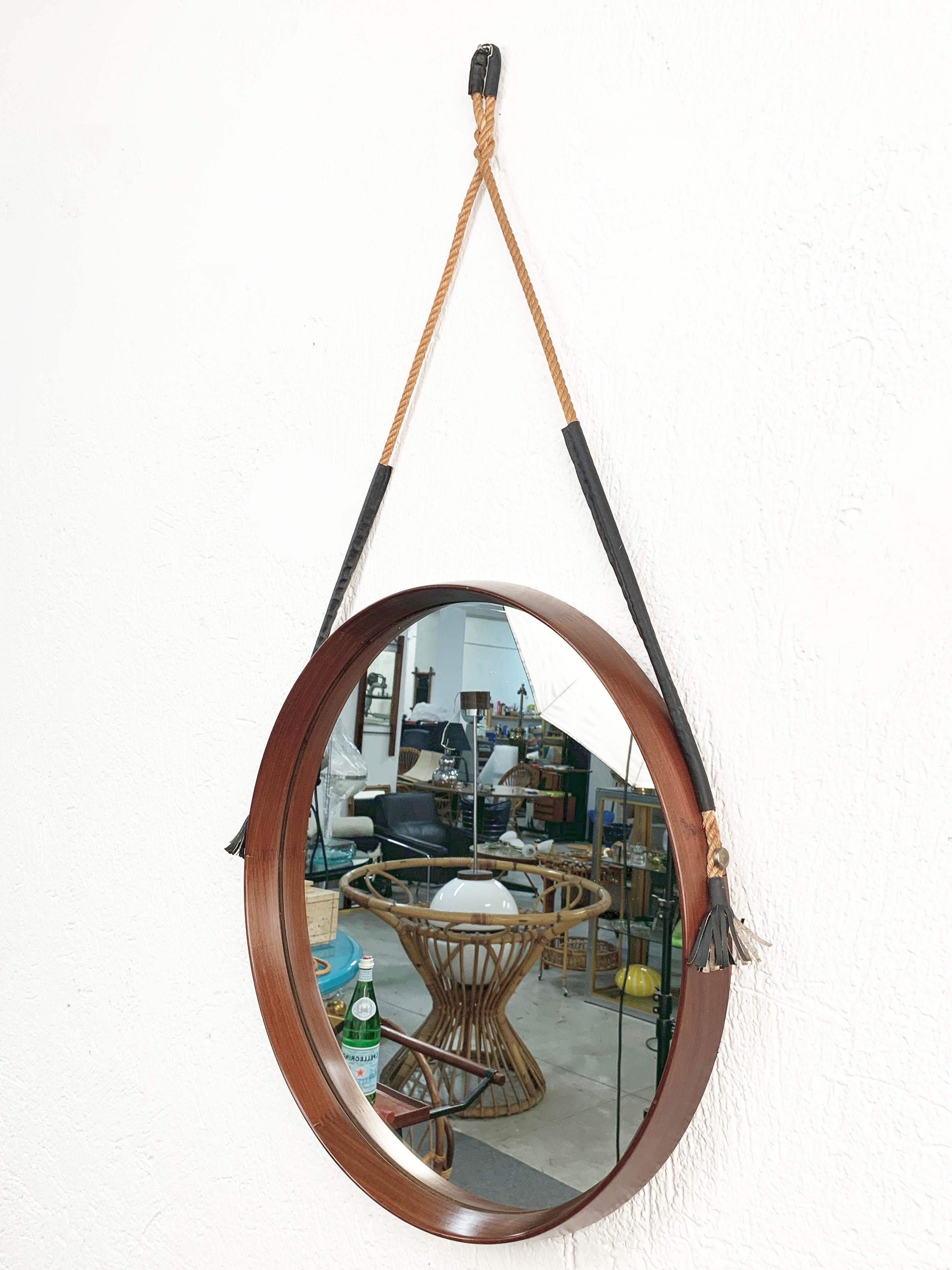 Vintage 1960s midcentury Italian round mirror with teak structure.

It can be hanged via a braided and black leather rope.

A fantastic item that will enrich a living room with its design and patina.