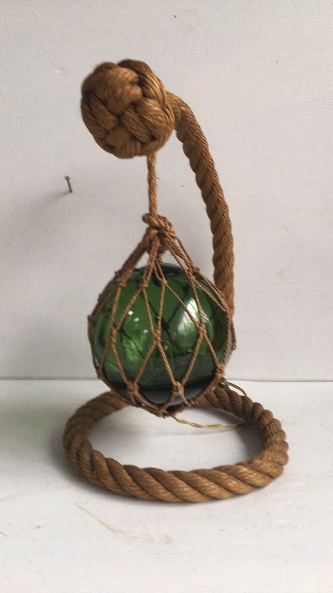 Midcentury rope lamp by Audoux Minet with a green glass float, circa 1960.
Measures: Height / 14.5