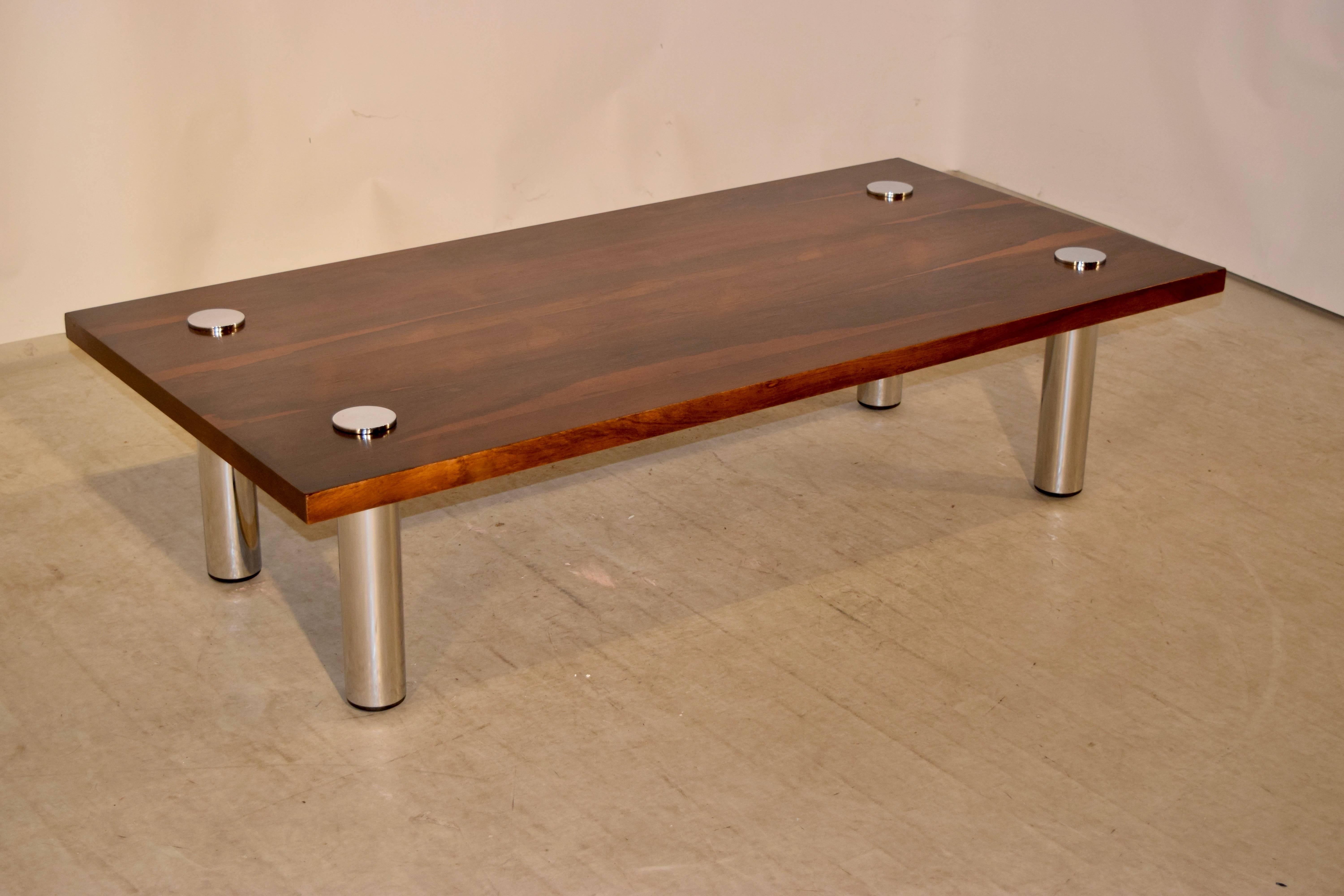 Mid-20th century rosewood coffee table from Europe with a fabulous top made of exquisitely grained rosewood with chrome legs. the chrome legs join through the top of the table for a  clean and modern look.  Simplistic and clean style with lovely