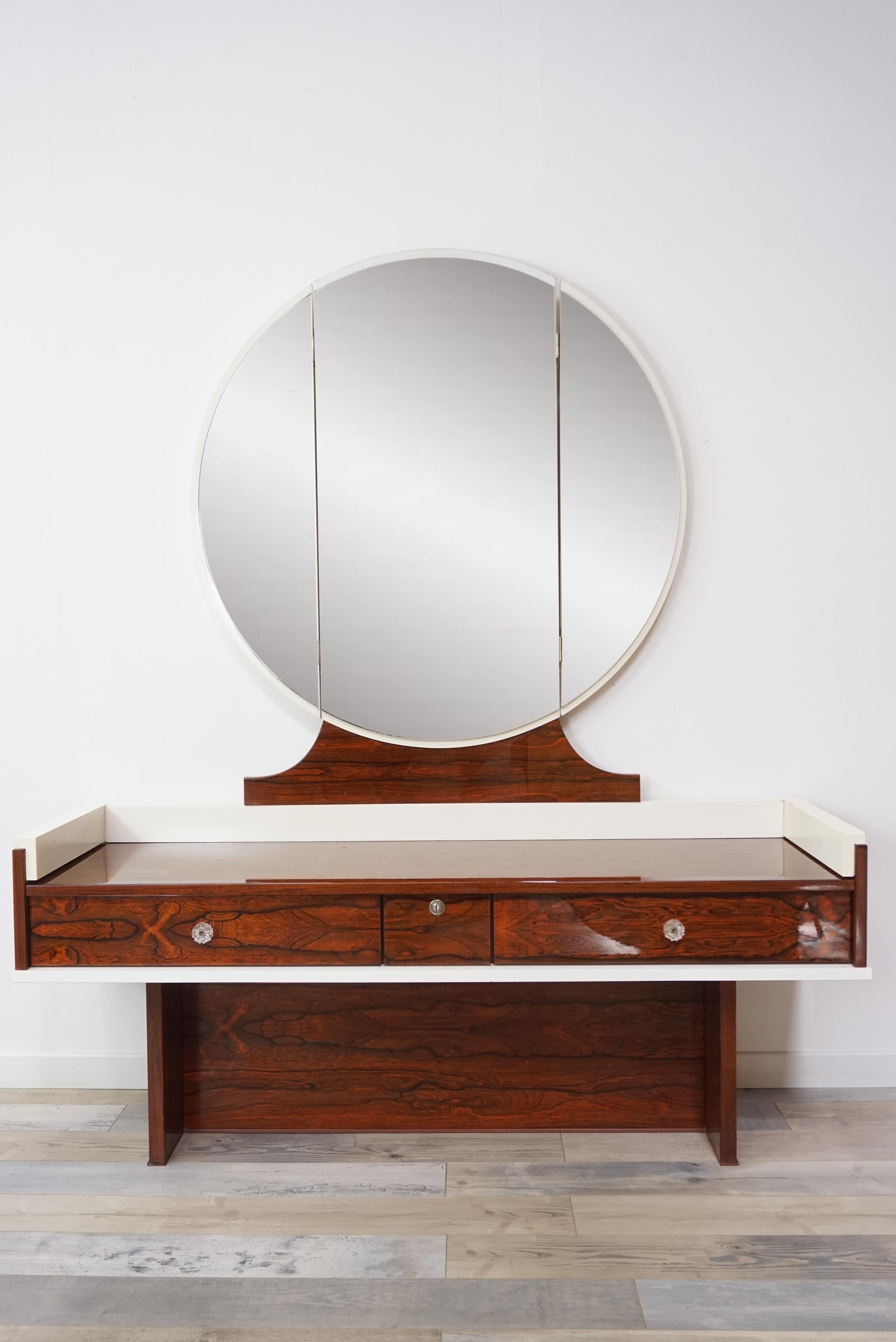Amazing and glossy dressing table from the 1960s-1970s composed of a wooden structure, rosewood and white lacquered, a triptych mirror and three chests of drawers decorated with diamond shape handles.