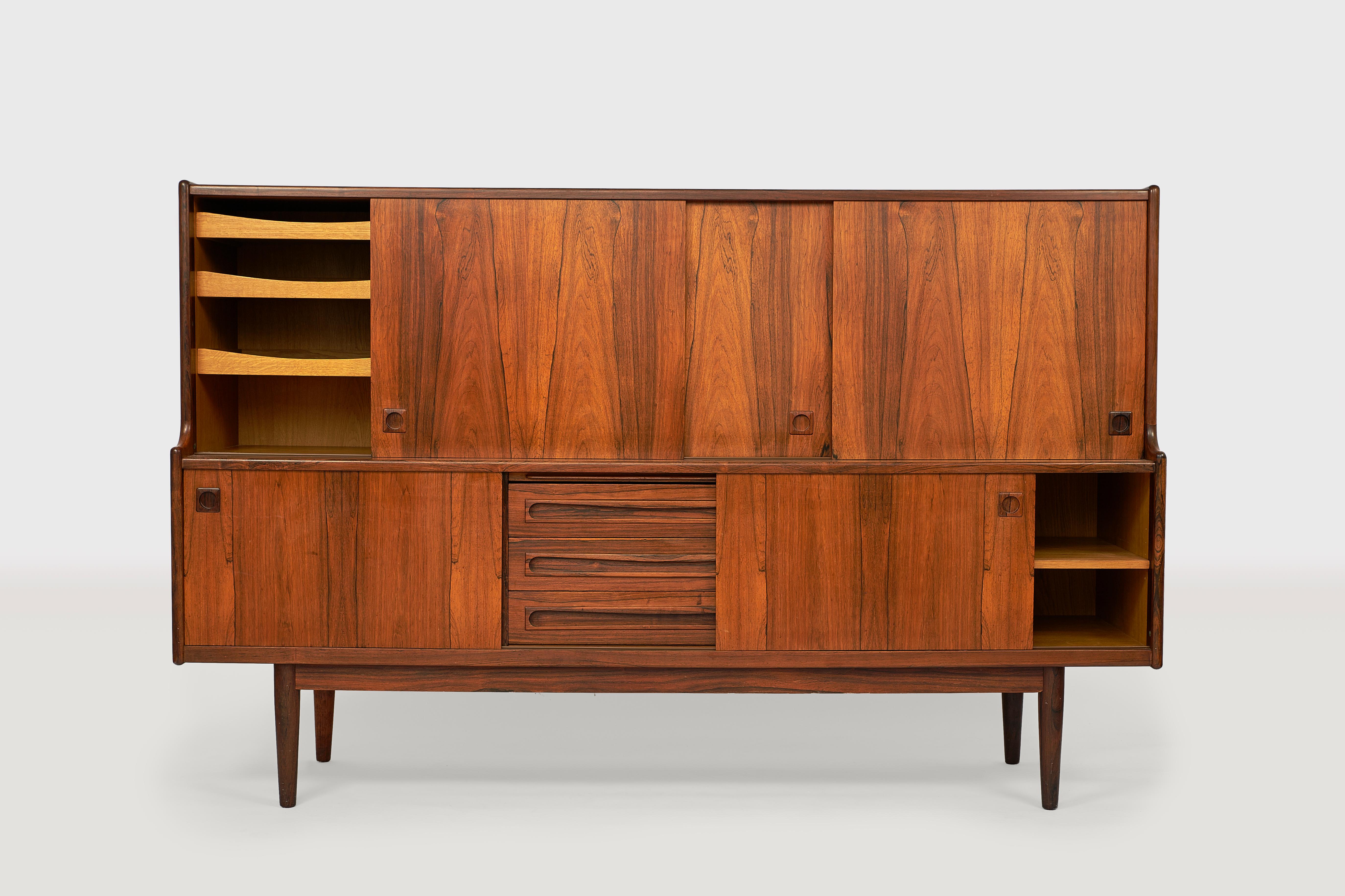 Midcentury rosewood cabinet by Johannes Andersen for Skaaning Furniture with elegant lines and excellent craftsmanship. The cabinet has five sliding doors and visible and hidden drawers and shelves. The cabinet is in very good condition with only a
