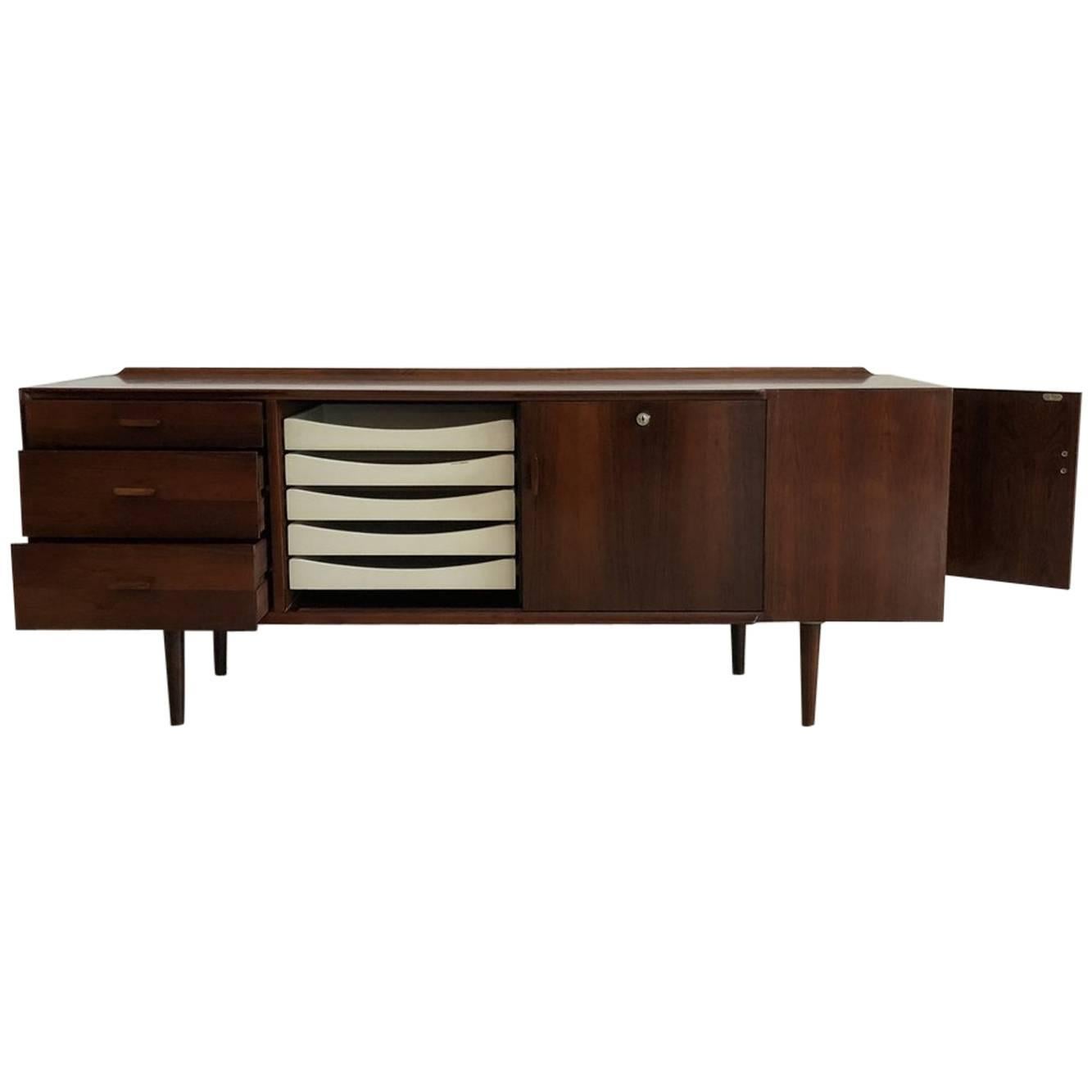 Super amazing Arne Vodder for Sibast rosewood sideboard, made in Denmark, circa 1950s. Stunning!

Has adjustable shelves in cubbies and five white signature “Vodder” drawers. Sliding doors on front. Hidden side cubby. Finished on all sides. Solid