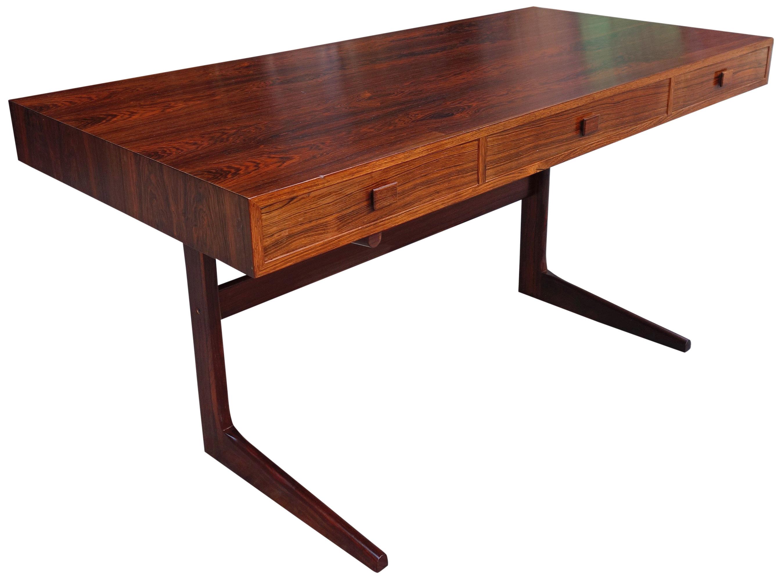For your consideration is this gorgeous desk featuring highly figured Brazilian rosewood on a rectangular form with three drawers, and a solid rosewood trestle base. A silver metal label is located on the underside. The drawers easily slide and are
