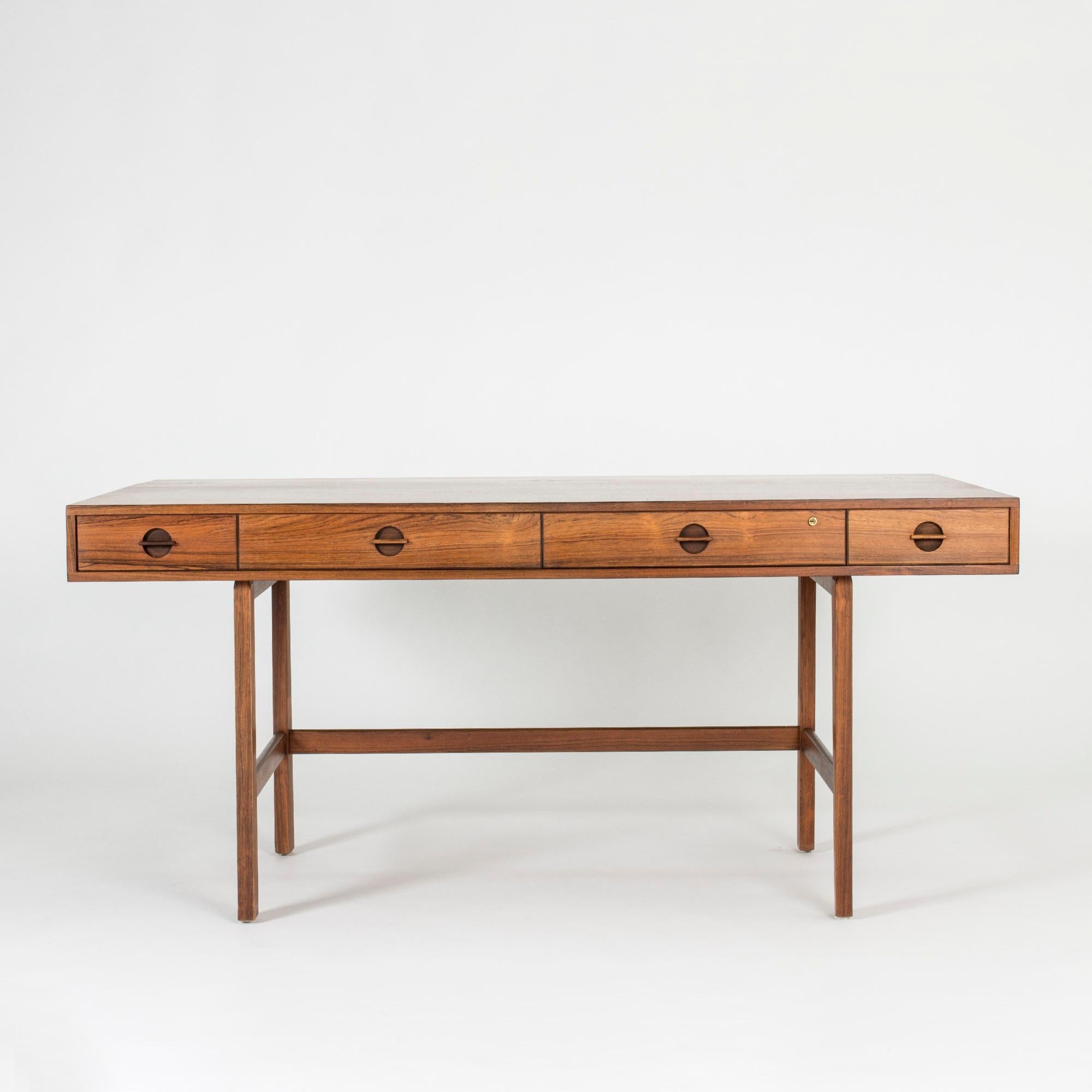 Amazing, versatile desk by Peter Løvig Nielsen, made in beautiful rosewood. The shelf on the tabletop can be flipped to extend the depth of the desk. Shelves on both sides. Nice attention to detail in the handles on the drawers and in the design of