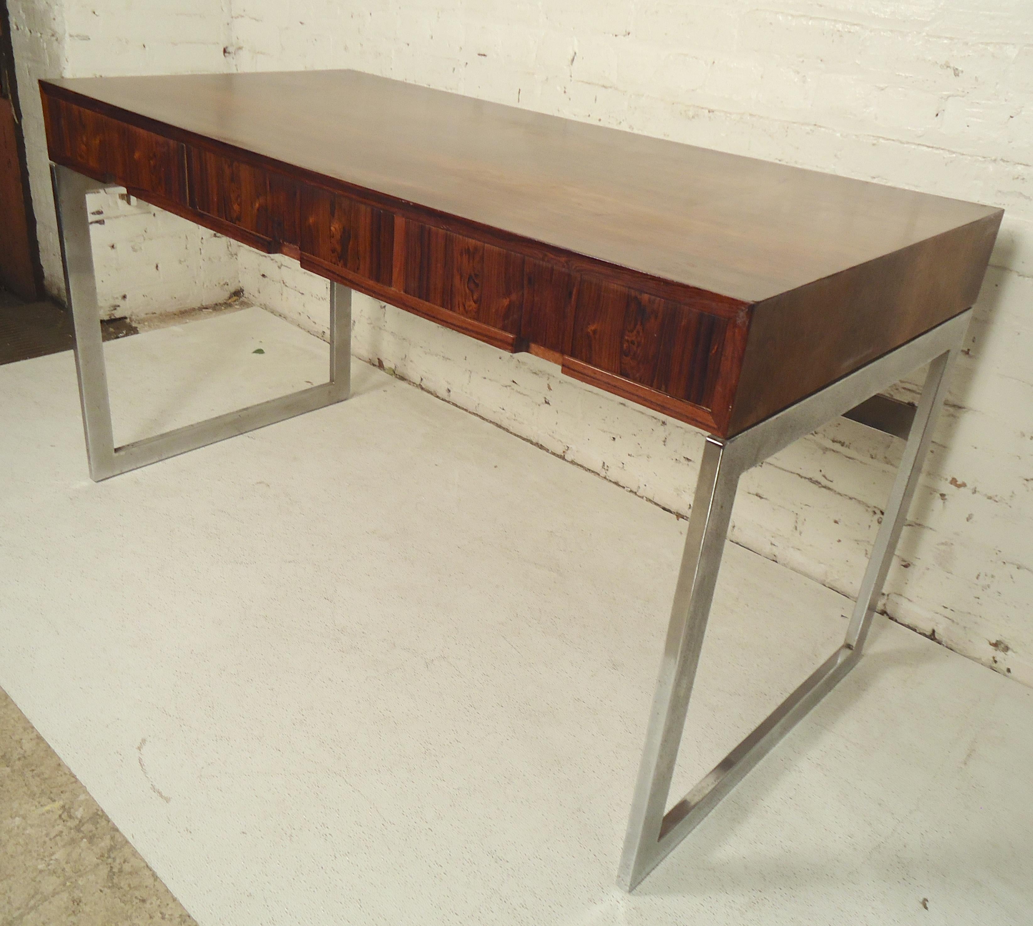 Sleek vintage desk with chrome base and rich rosewood surface. Three drawers and finished back.

(Please confirm item location - NY or NJ - with dealer).
  