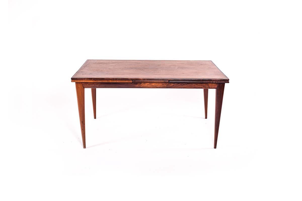 A rosewood dining table by Niels Moller for J.L. Moller, model 12. The design of this piece is ingenious. The quality of this piece is magnificent. Solid rosewood banding and legs are used in the construction. The convex leg detail adds beauty to