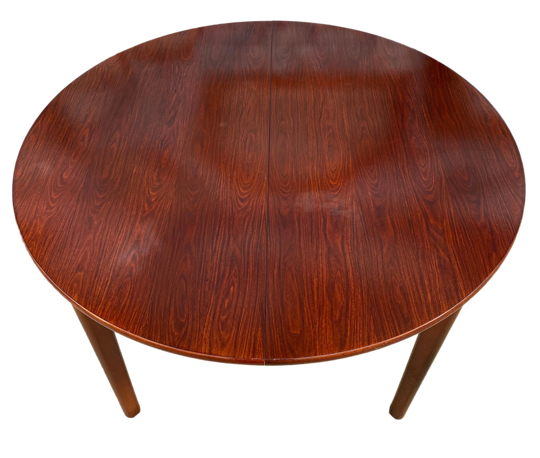 Midcentury rosewood expandable round dining table with 1 nesting leaf. This is a beautiful dining table Made in Denmark. Amazing solid wood legs. Made, circa 1960. Original finish in excellent condition. Documented AM Mobler. Measures: 48