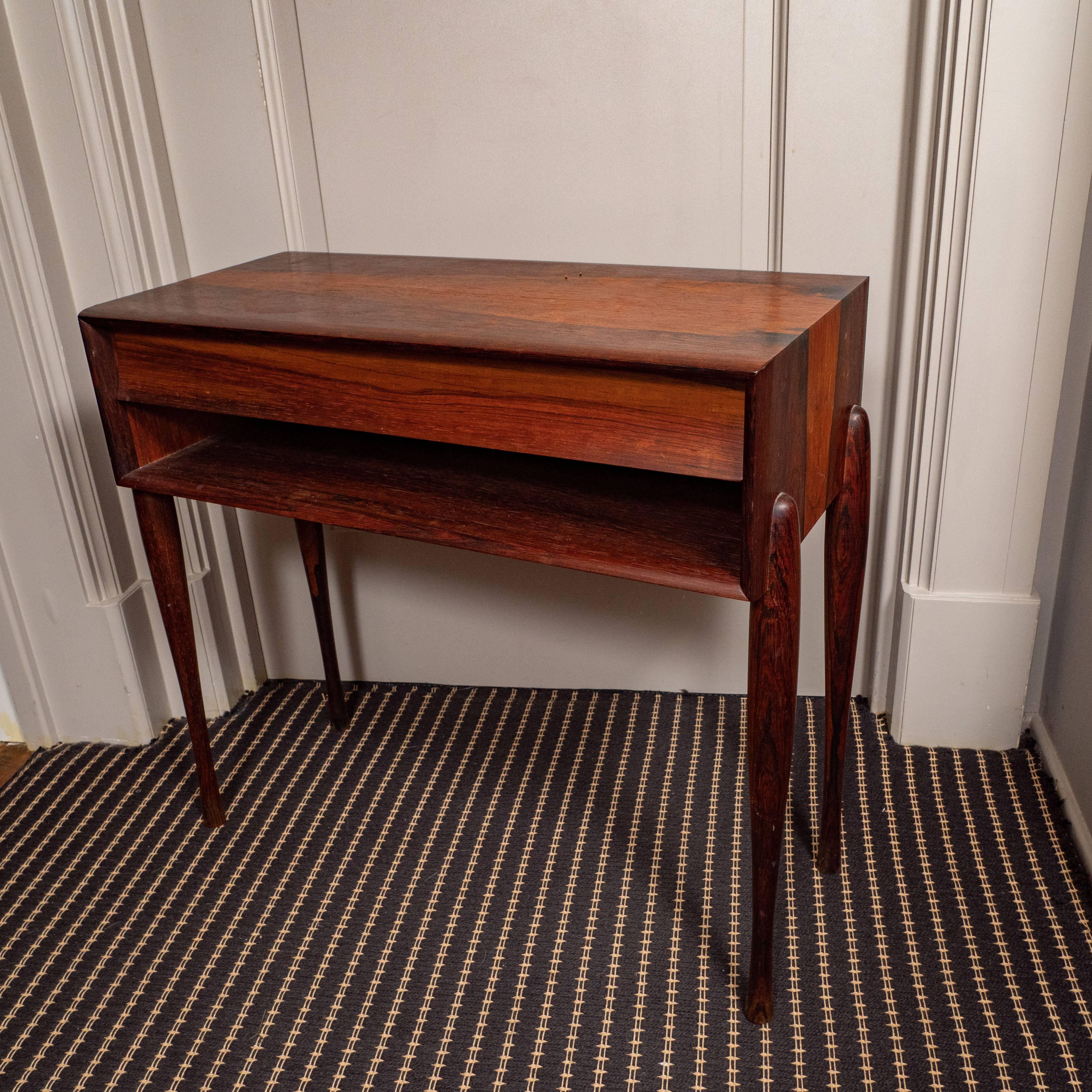 Midcentury side table with shelf. This is a stunning side table with beautiful section of the tree showing lots of variation. The legs are particularly lovely, a rounded taper exposed from the sides. This is a lovely midcentury piece. Probably