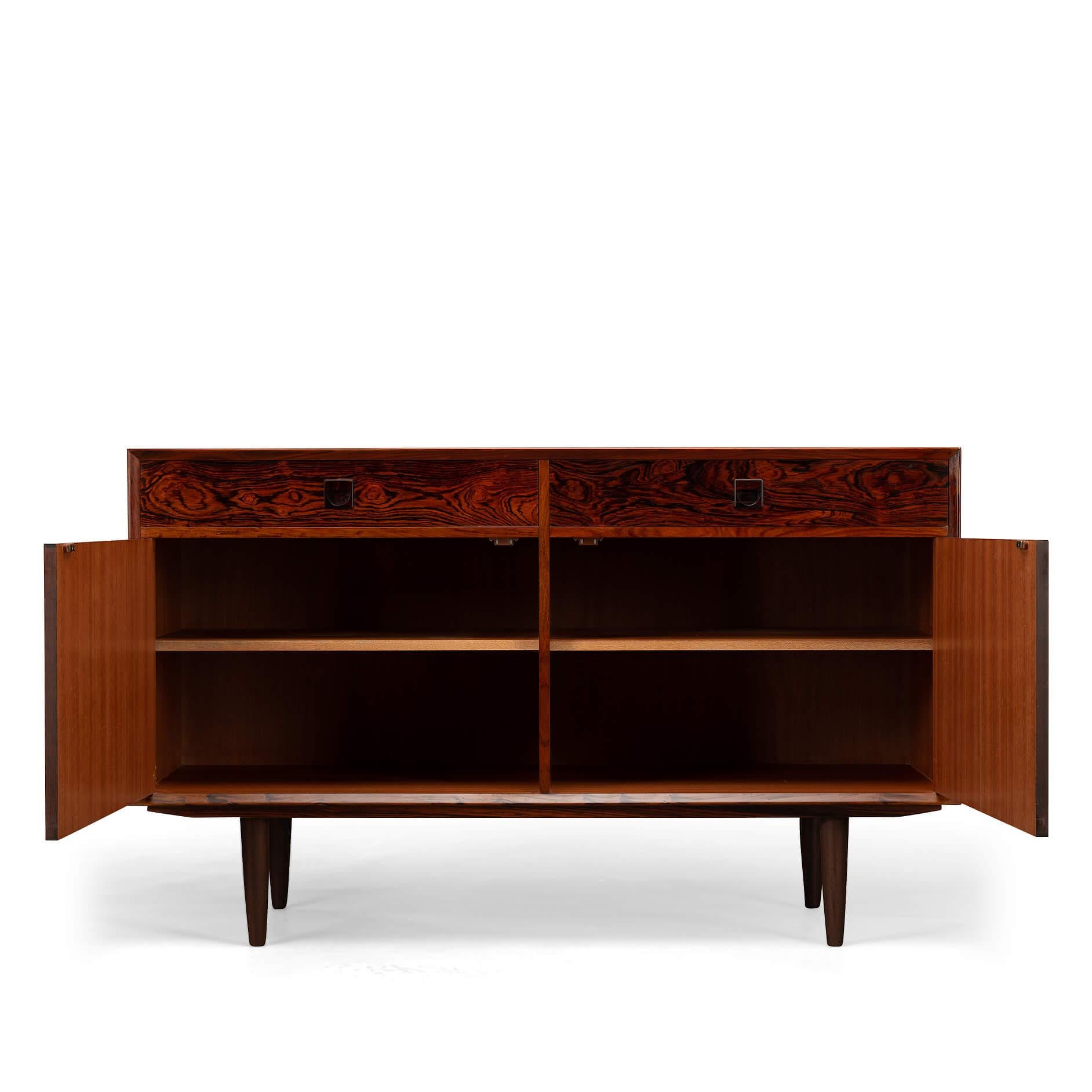 Small rosewood sideboard designed by E. Brouer and manufactured by Brouer Møbelfabrik. The expressive print of the rosewood on the doors is gorgeous! An eye-catcher in every hallway, study or living! This sideboard has a top layer of two drawers